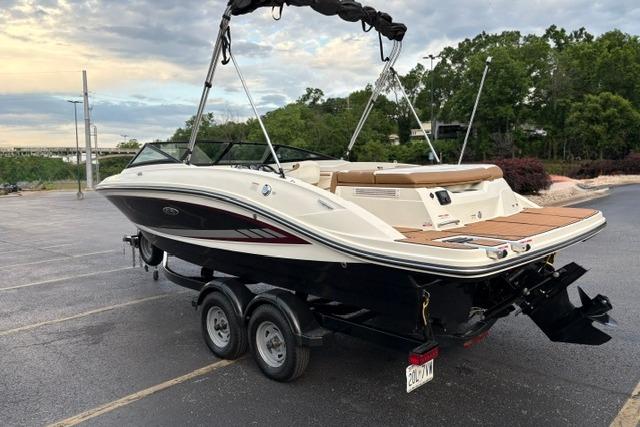 2017 Searay SPX210 boat on trailer in parking lot, surrounded by trees.