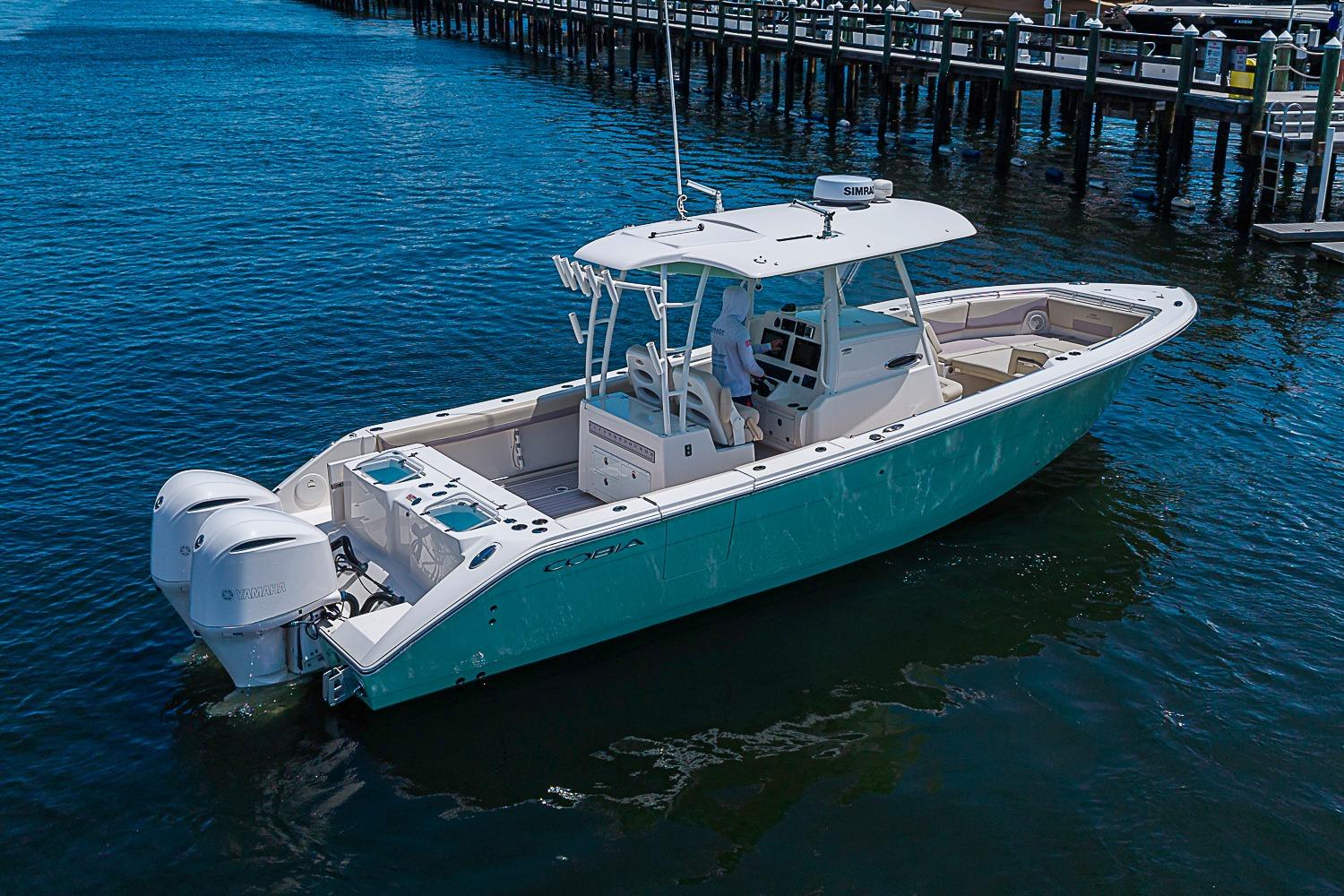 2019 Cobia 320 Center Console boat on water, featuring twin Yamaha engines.