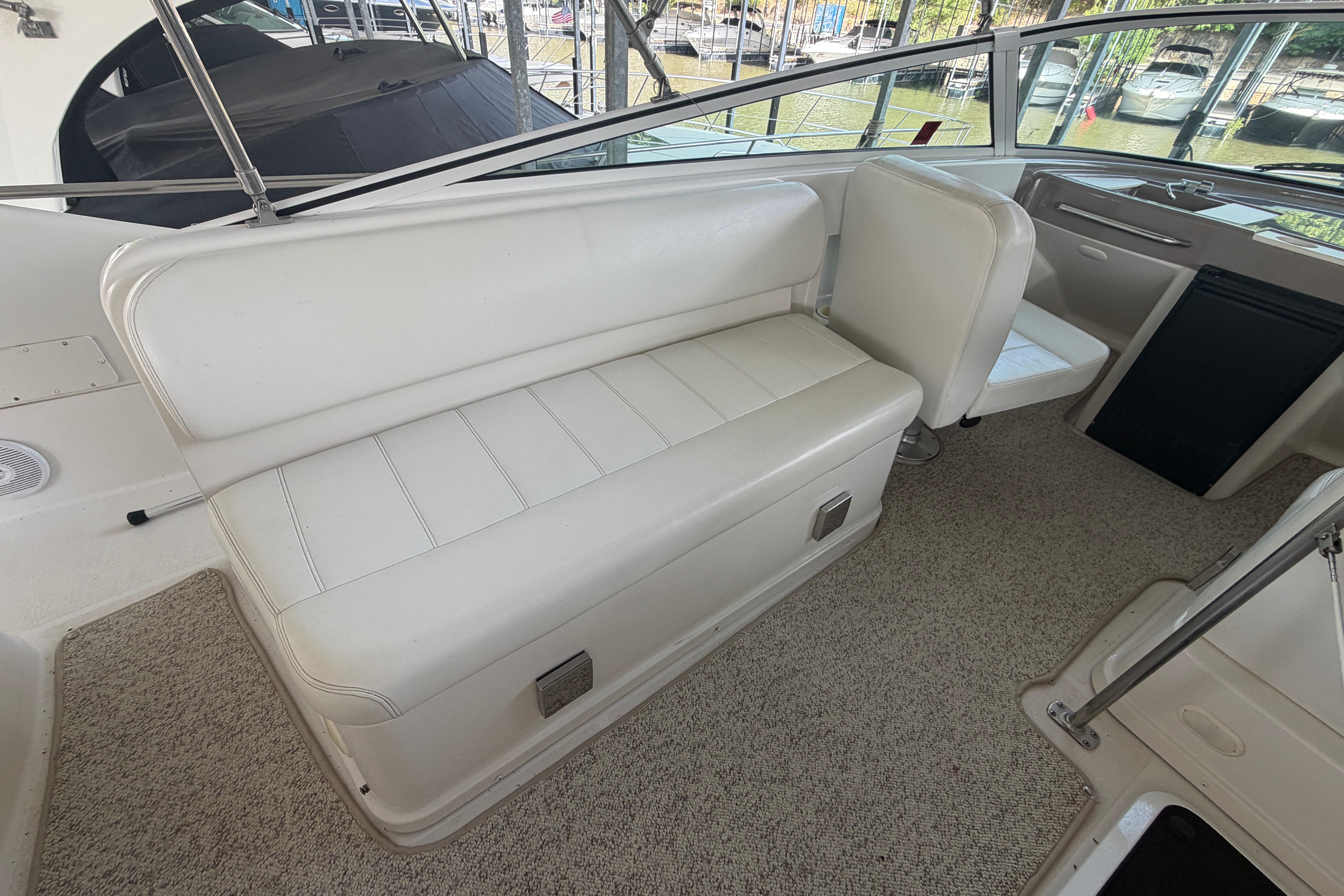 Interior seating of 2000 Carver 350 Mariner yacht, featuring white upholstery and carpeted flooring.
