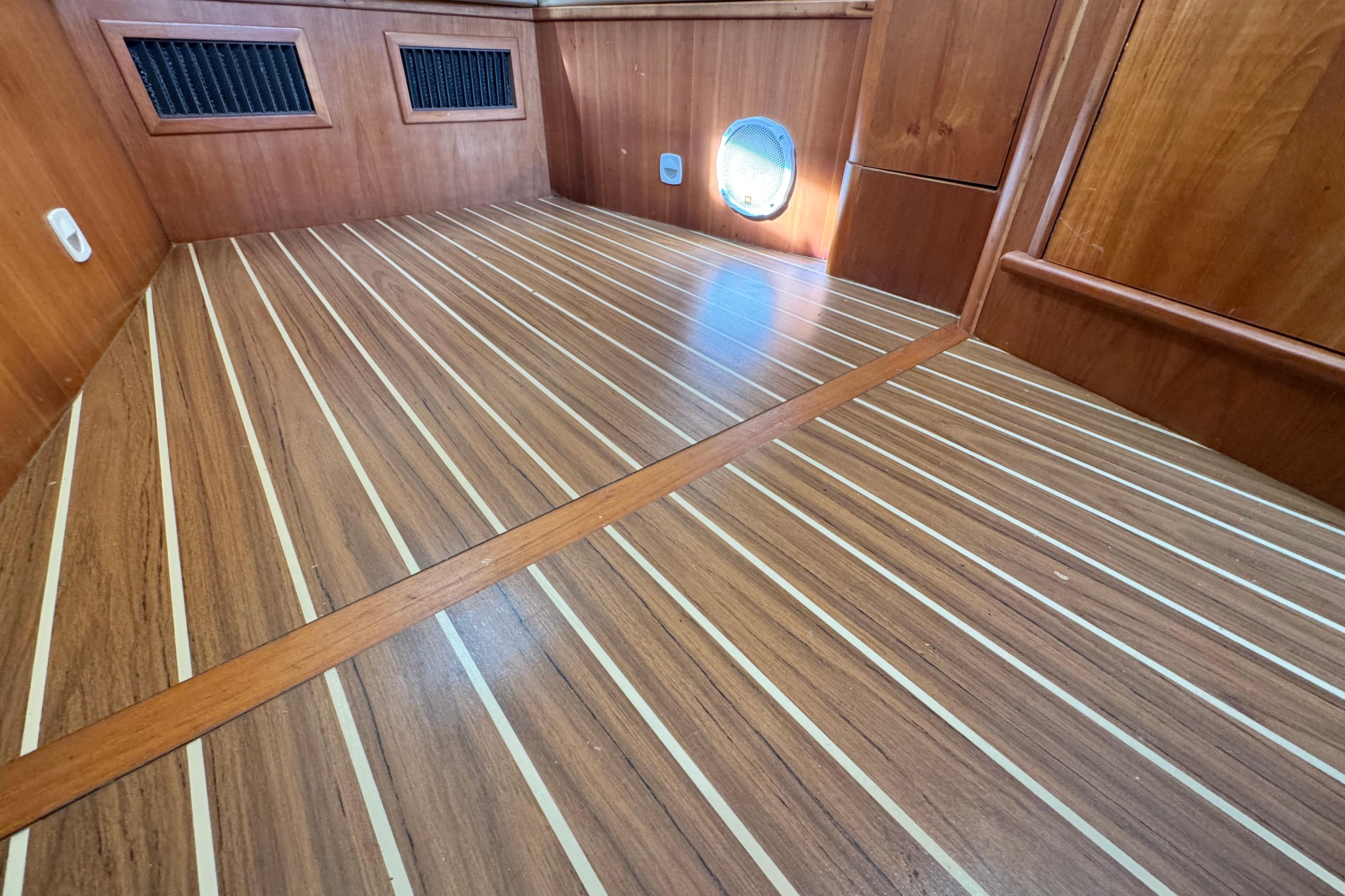 2004 Mainship Pilot 30 Rum Runner interior with wood paneling and striped flooring.