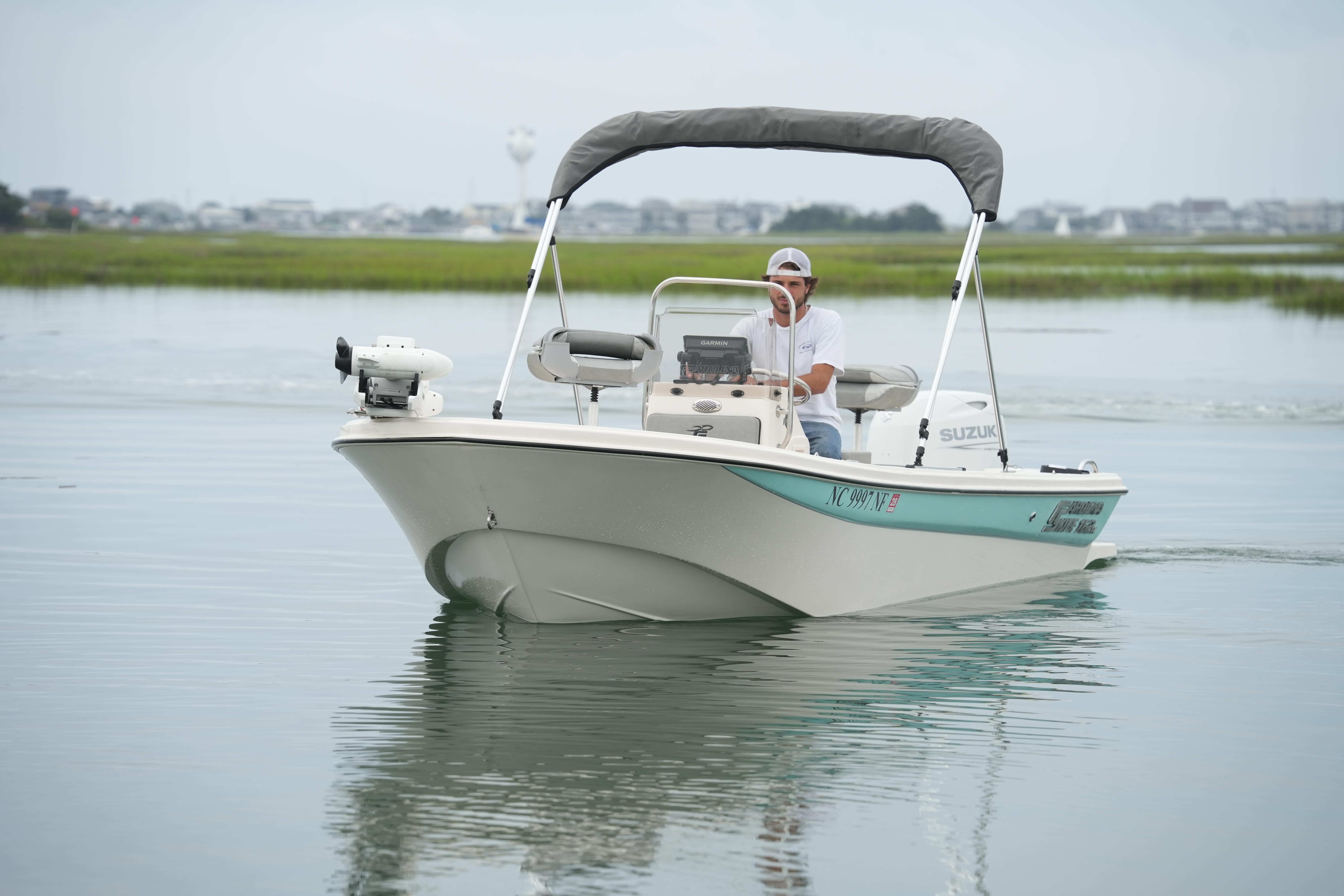 2025 Carolina Skiff 162 JLS boat cruising on calm water with a canopy.