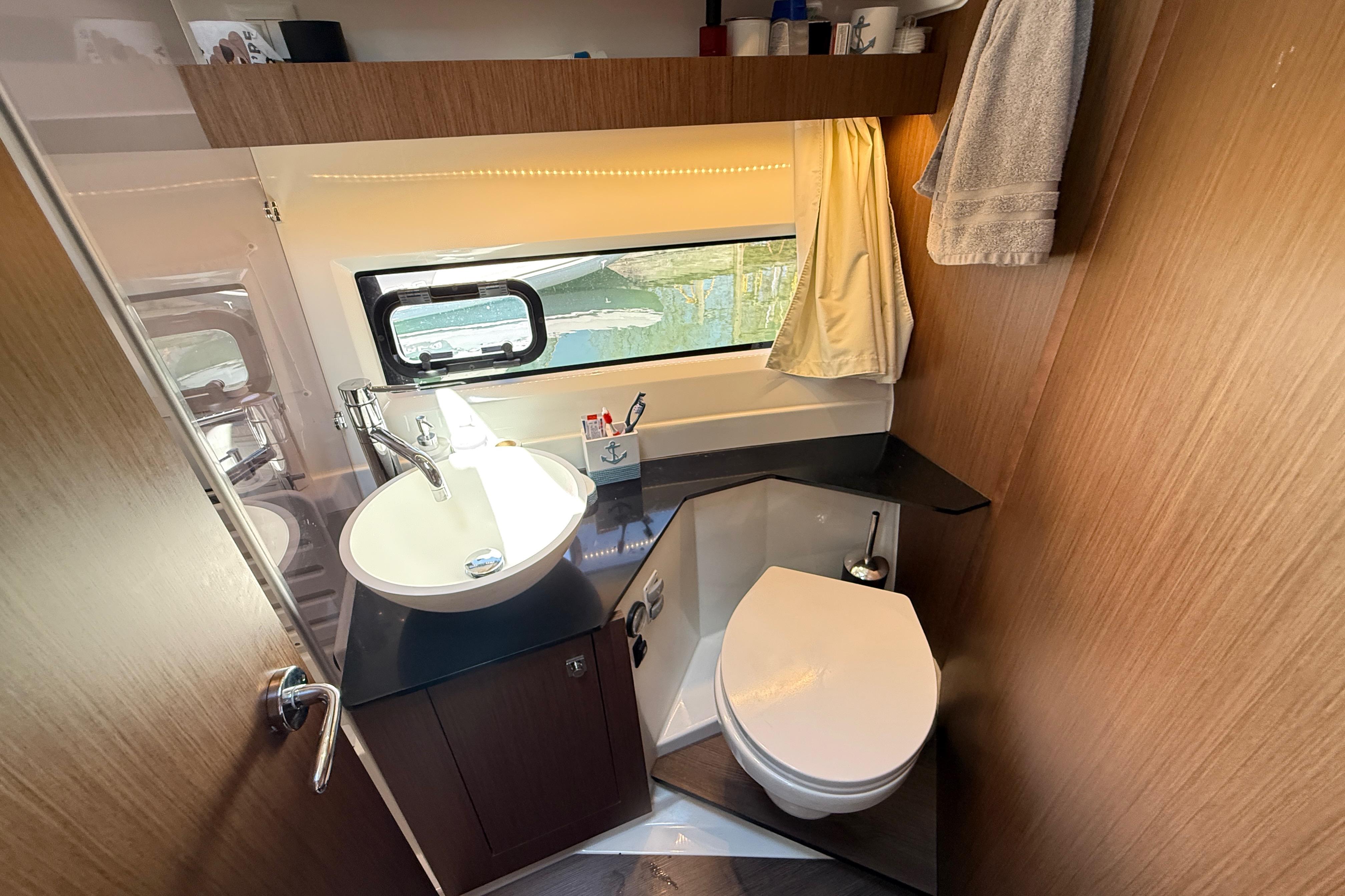 Bathroom interior of 2022 Jeanneau NC 1095 Fly yacht, featuring sink and toilet.