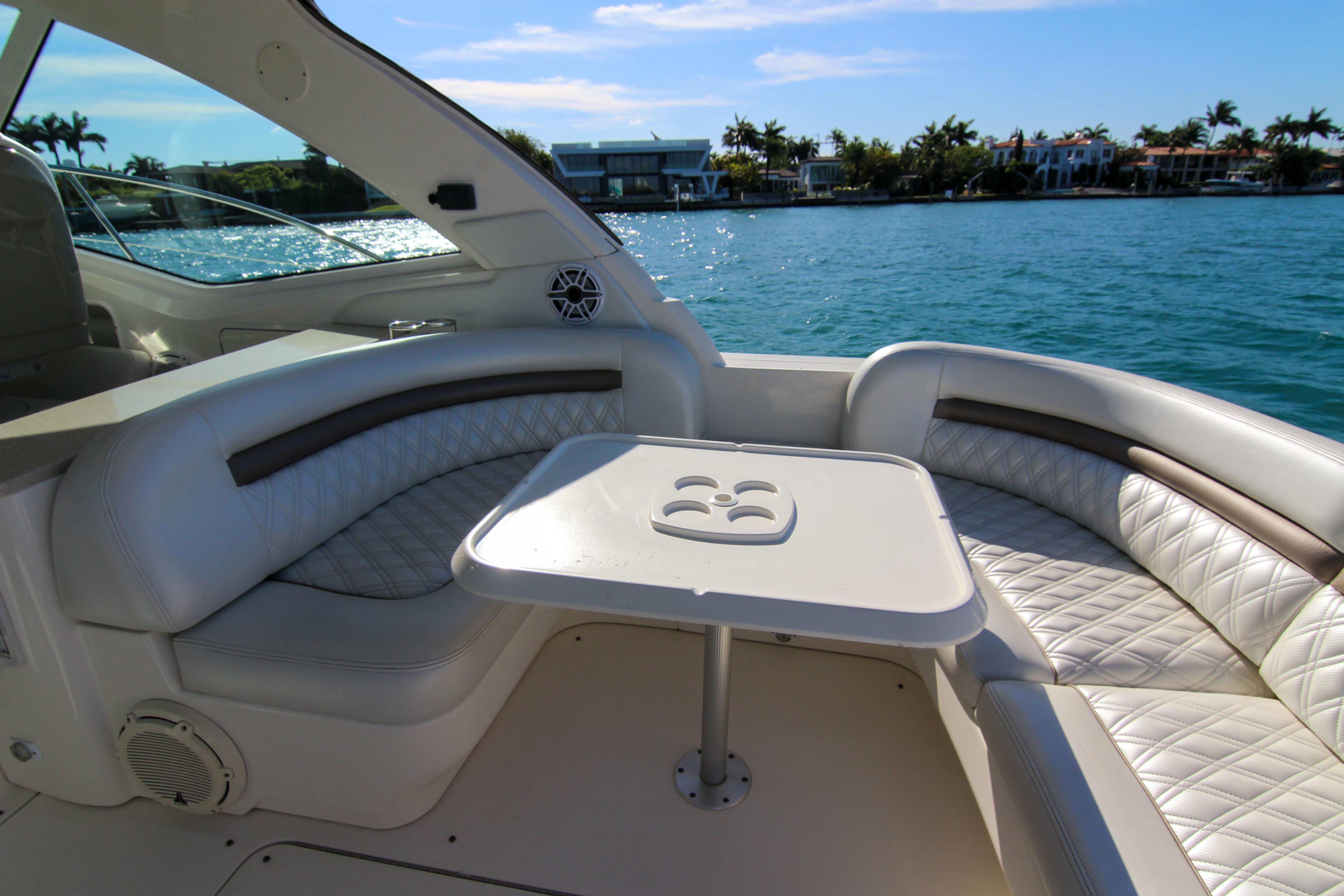 2008 Sea Ray 48 Sundancer yacht interior with plush seating and table, overlooking serene water.