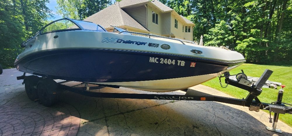 A 2007 Sea-Doo Sport Boat 230 Challenger SE on a trailer, parked on a driveway.