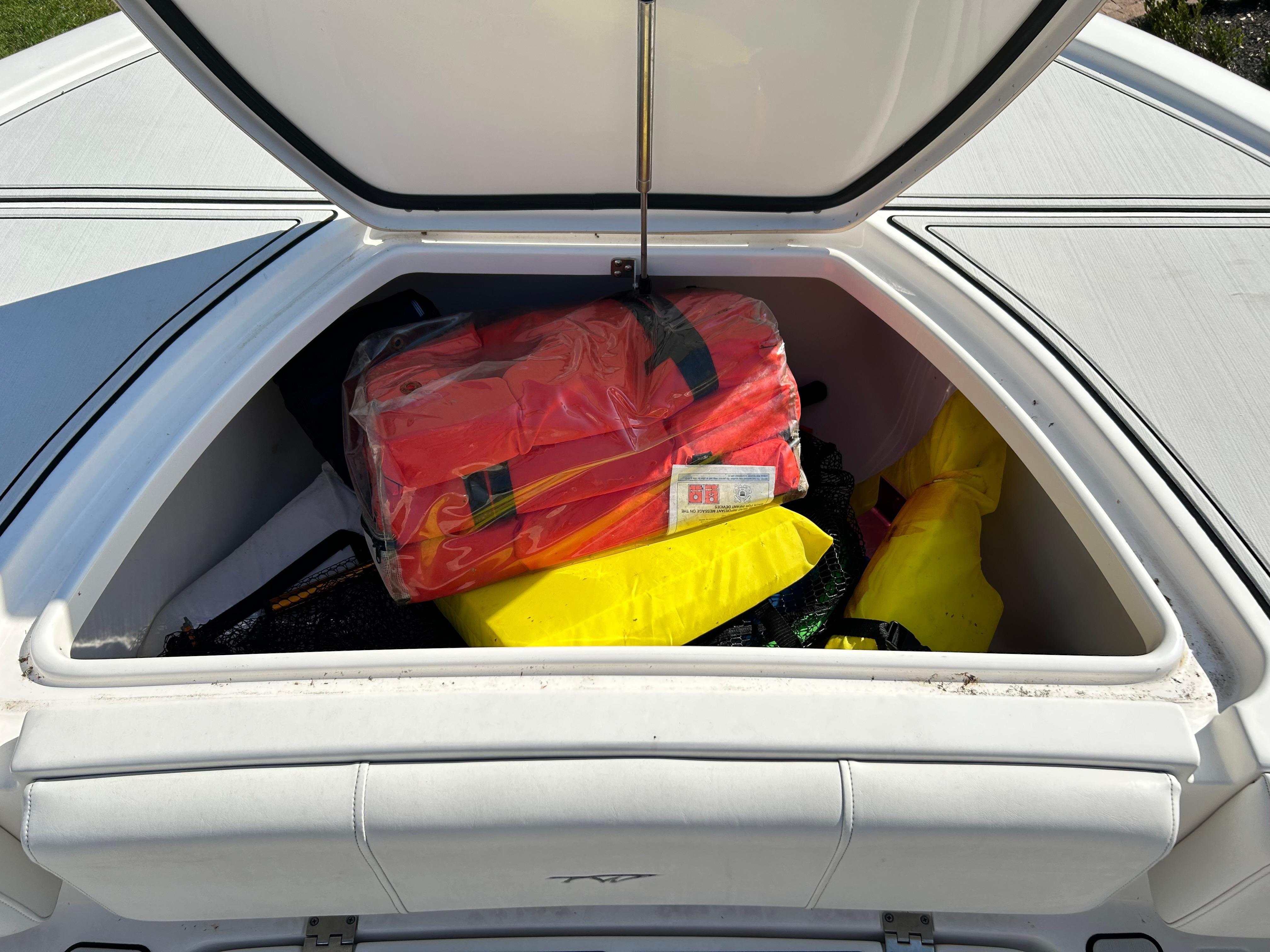 Open storage compartment on 2018 Tidewater 2700 Carolina Bay boat with safety gear.