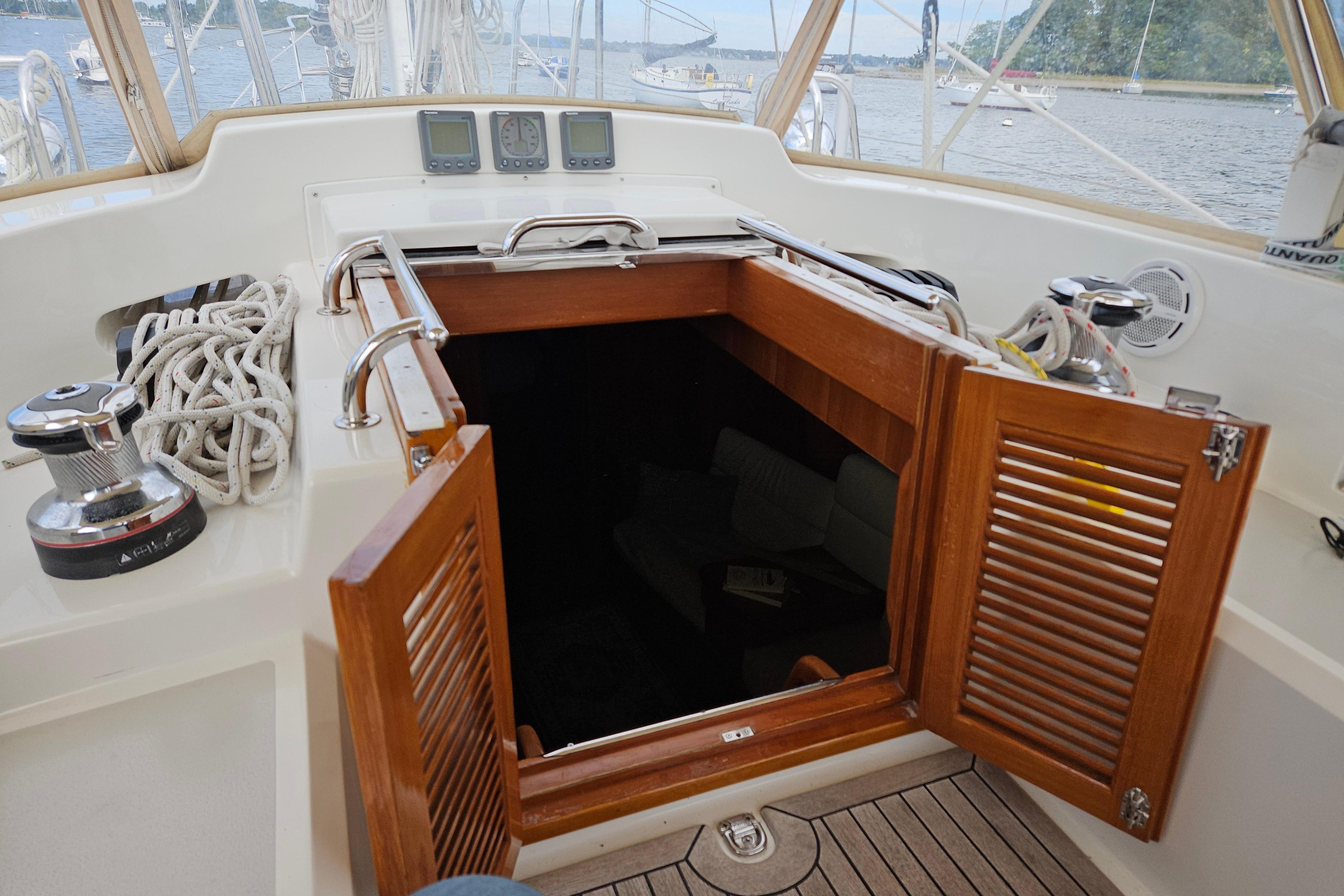 Cockpit of 2013 Passport 470 Center Cockpit sailboat with open wooden hatch.