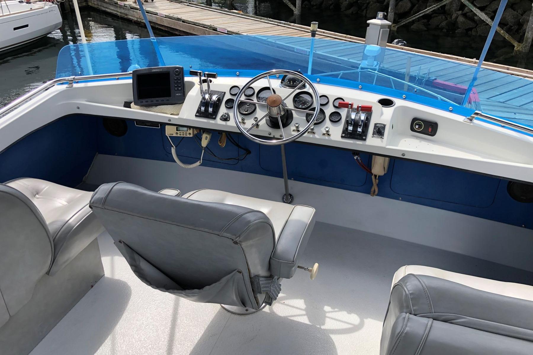 1988 Commander 30 Command Bridge helm with steering wheel, controls, and navigation equipment.