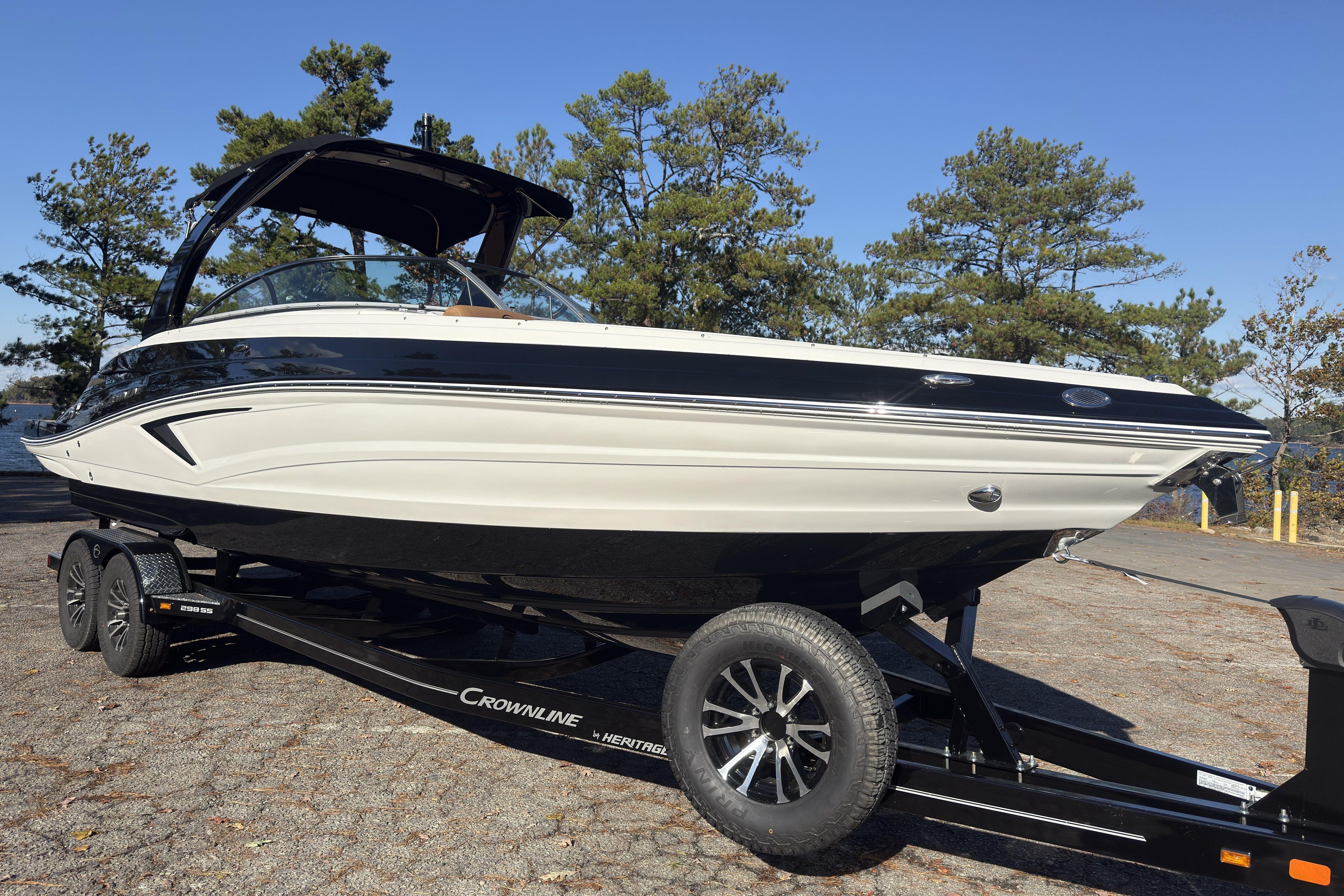 2026 Crownline 298 SS boat on trailer, parked outdoors with trees in background.