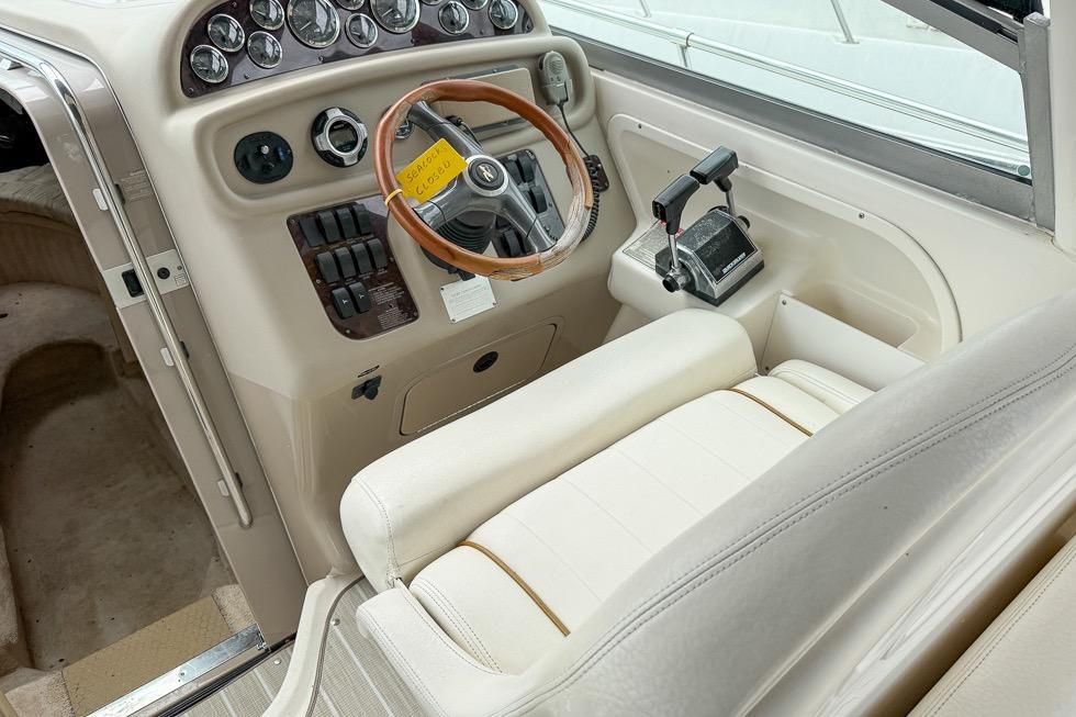 1999 Sea Ray 290 Sundancer helm with wood-accented steering wheel and control panel.