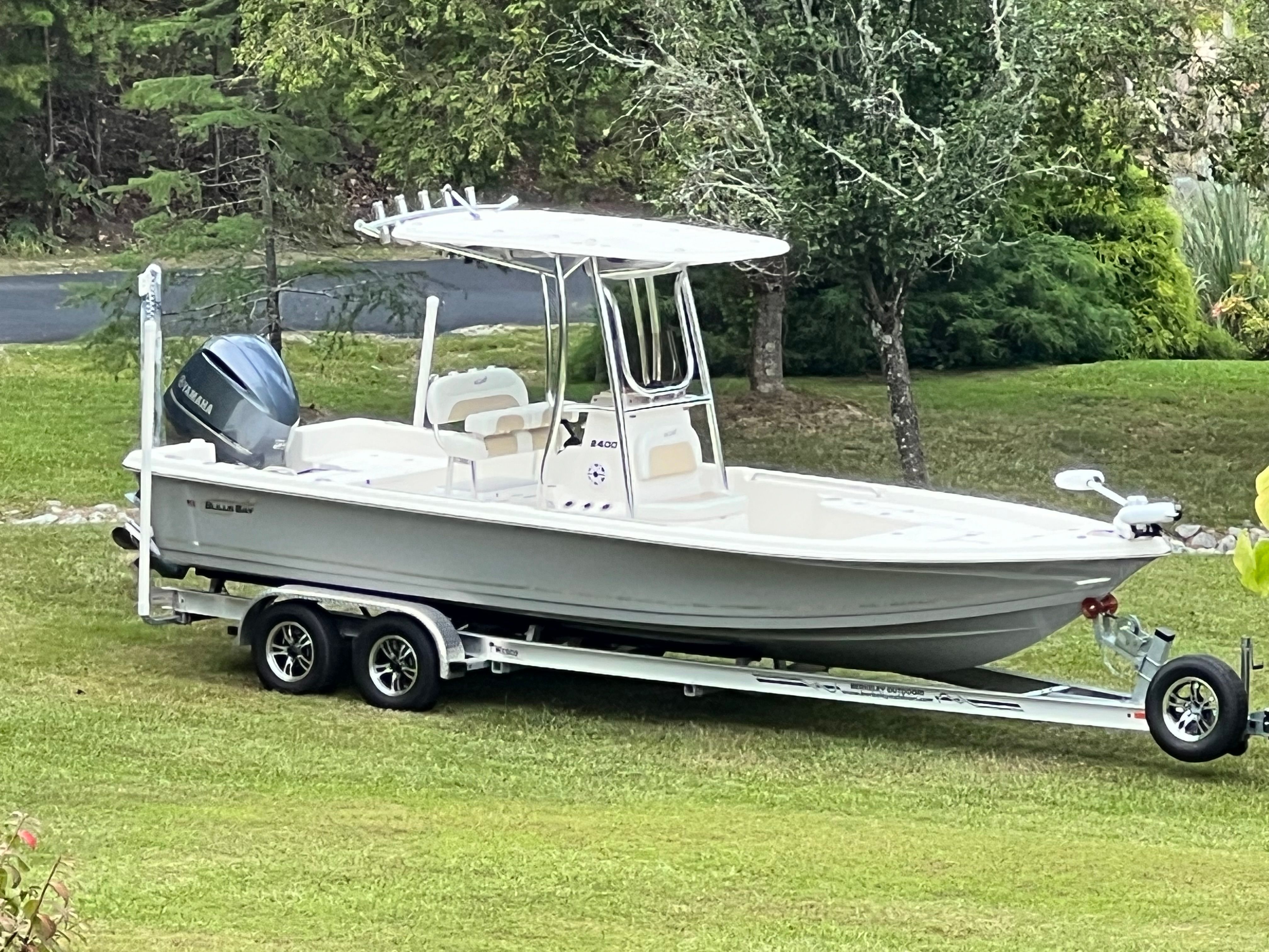 Bulls Bay 2400 boat from 2023 on a trailer, parked on a grassy lawn.