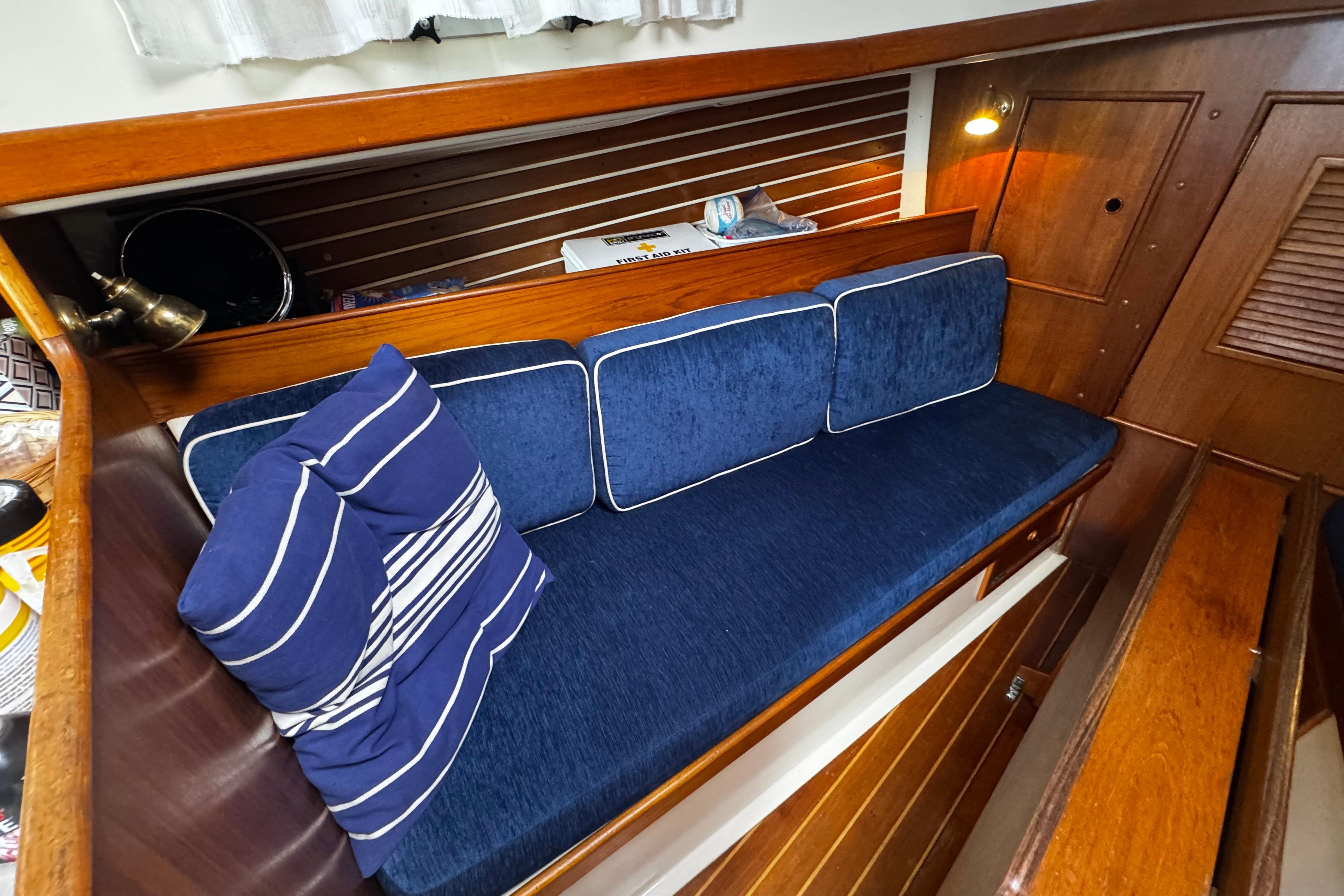 1984 Nonsuch 26 Classic interior with blue cushioned seating and wooden paneling.