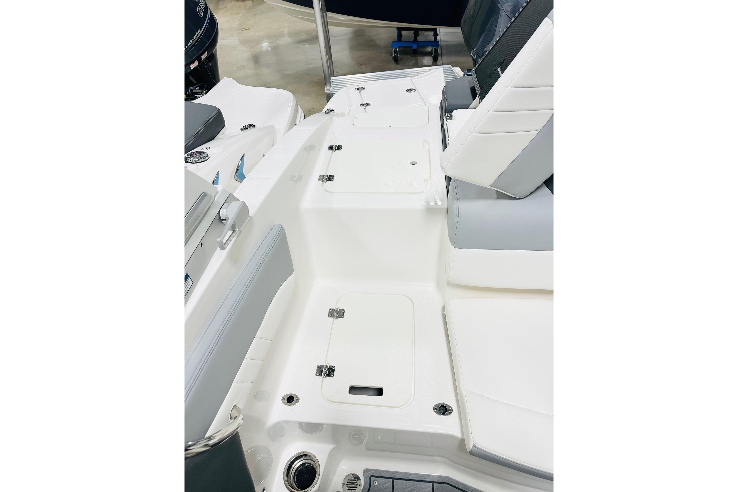 2025 Chaparral 21 SSi OB boat interior with white seating and storage compartments.