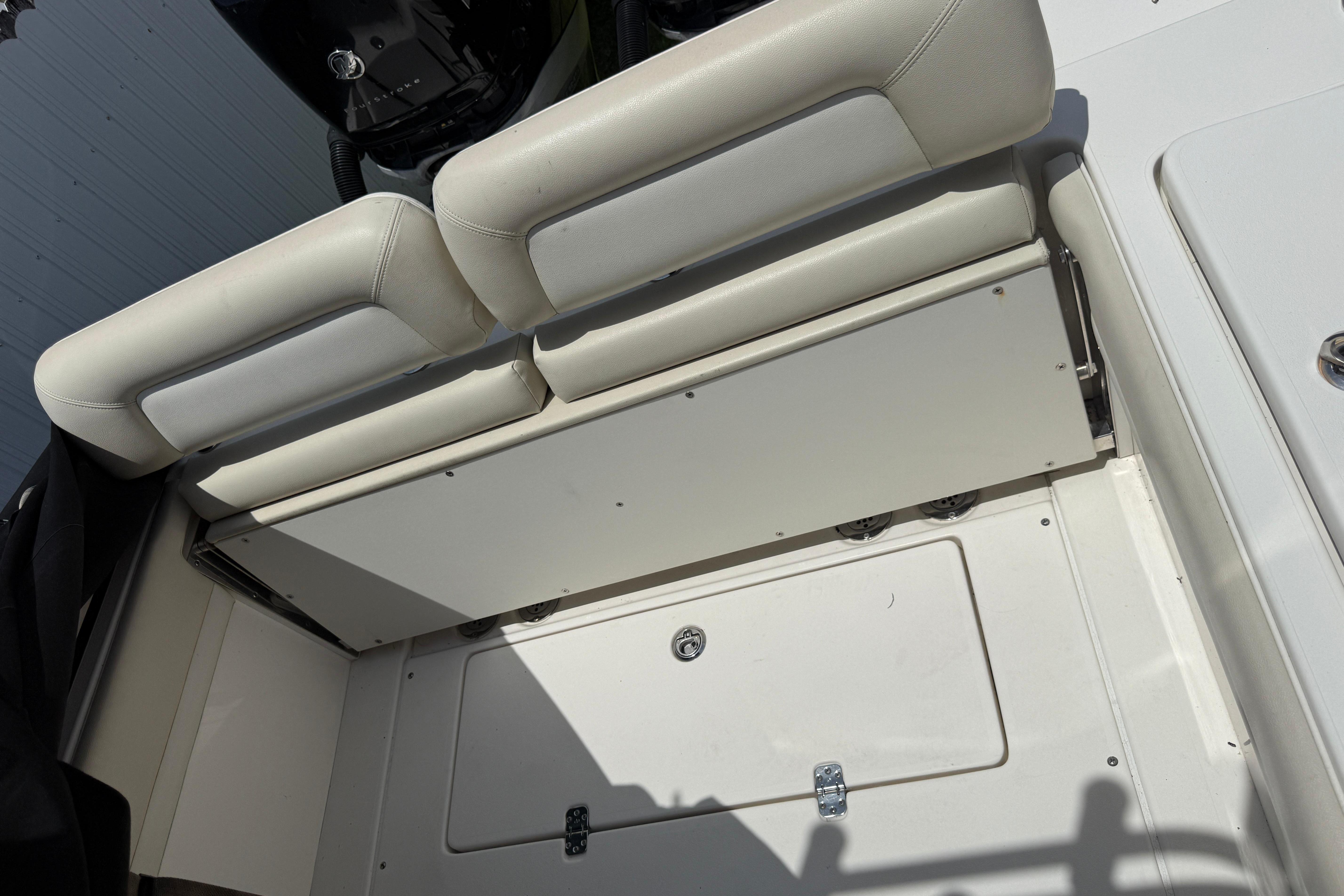 2015 Blackwood 27 boat interior with white cushioned seating and storage compartment.
