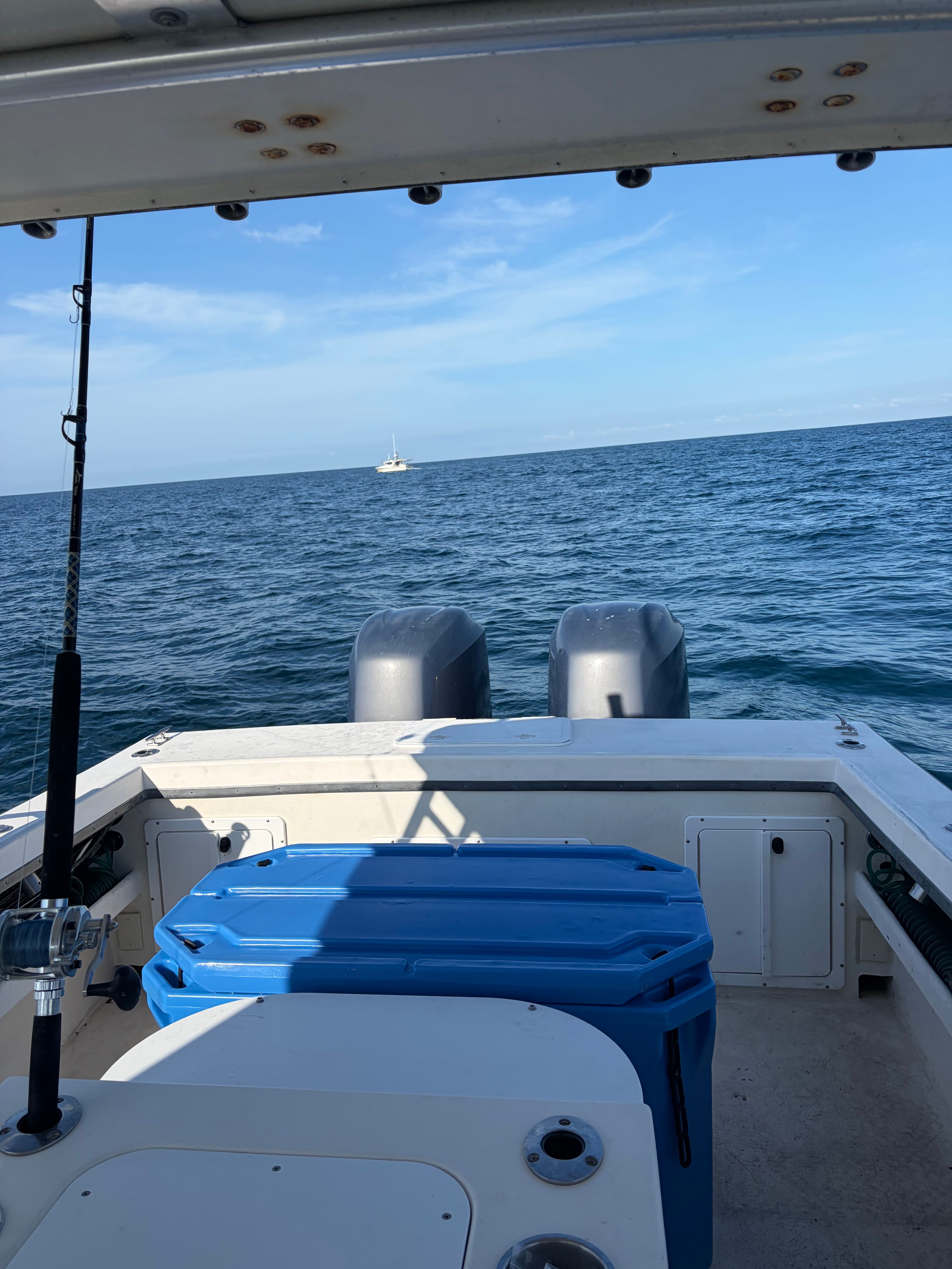 View from the stern of a boat with two engines, looking out to open sea.