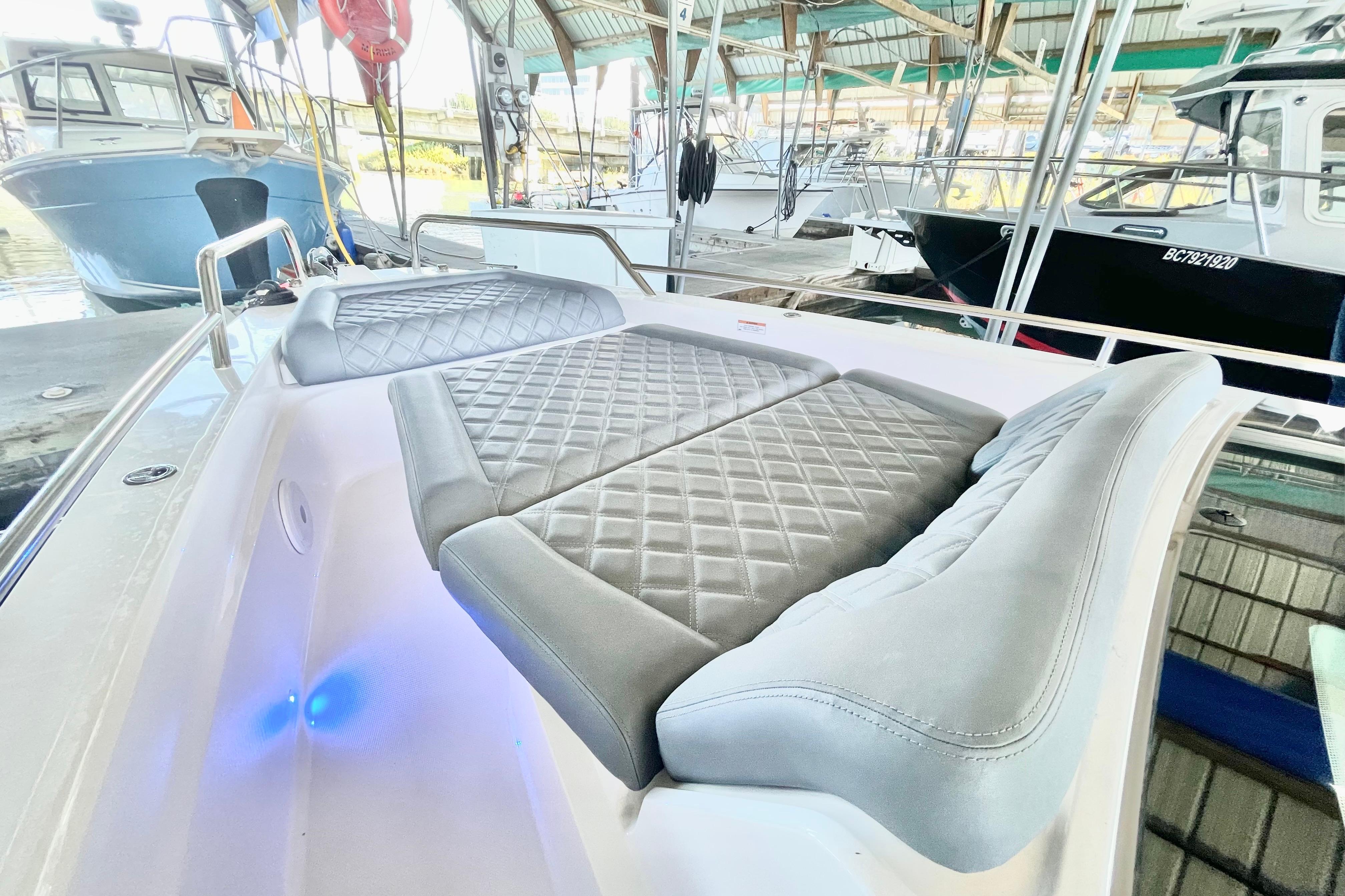 Luxurious seating on 2021 Axopar 37 XC CROSS CABIN boat in marina setting.
