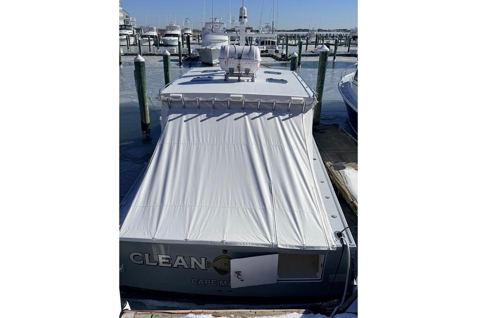 2025 Wesmac 42 boat docked with protective cover in marina.