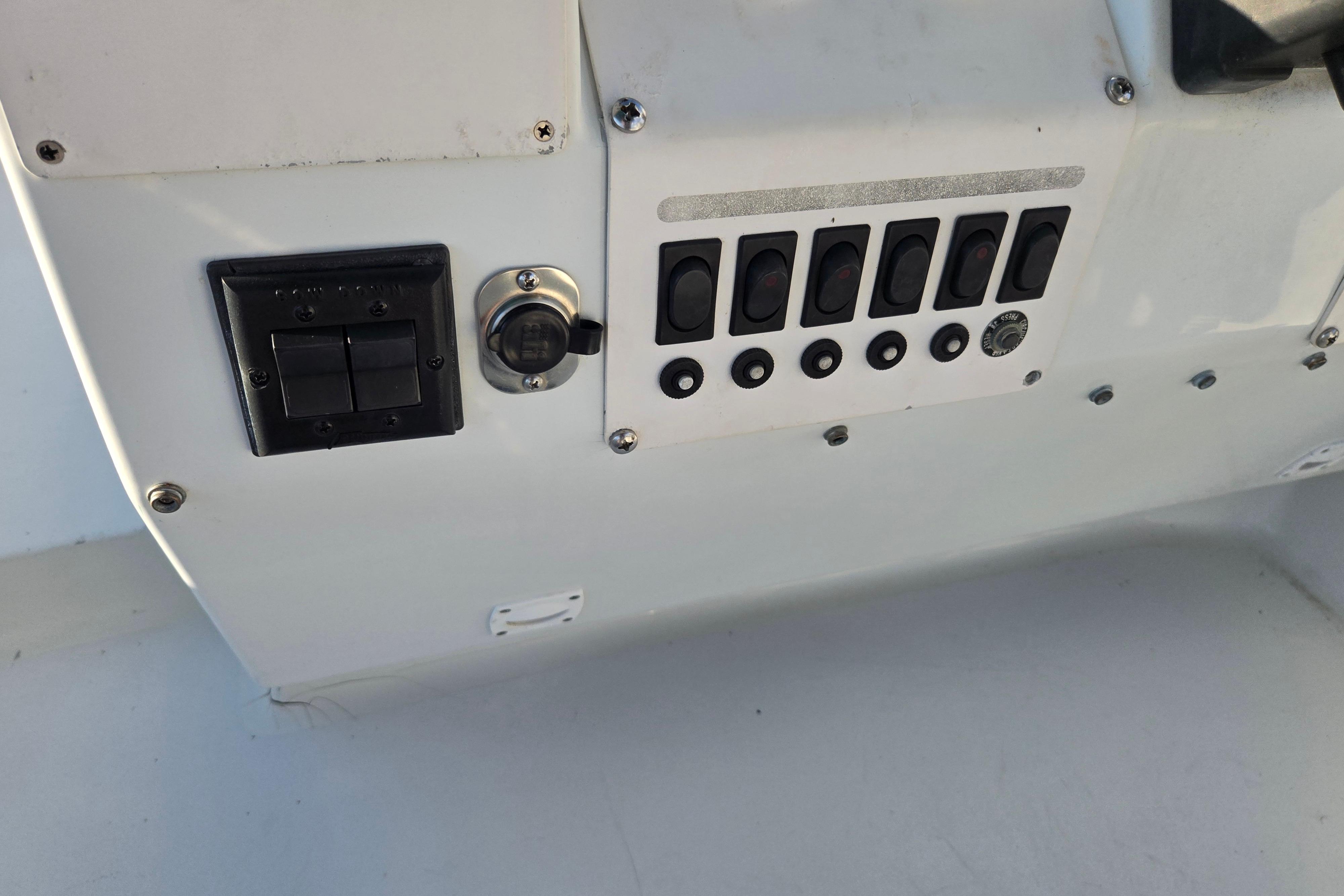 Control panel of a 1991 Mainship 35 Open Bridge boat with switches and dials.