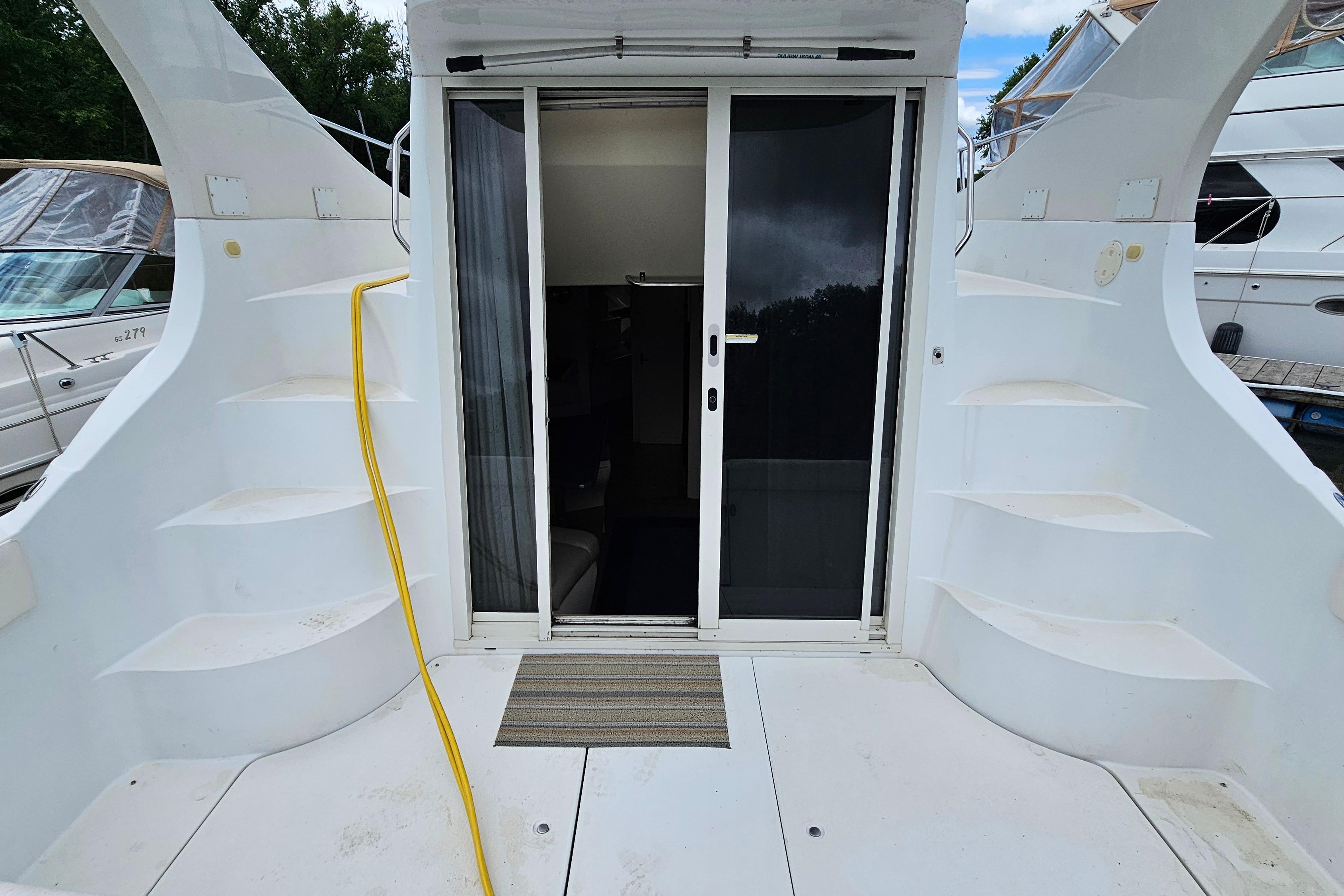 1999 Carver 350 Mariner yacht with sliding glass door and exterior steps.