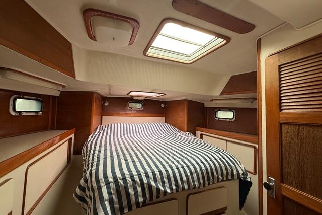 Cozy cabin interior of 1987 Irwin 38 Mk II sailboat with striped bedding.
