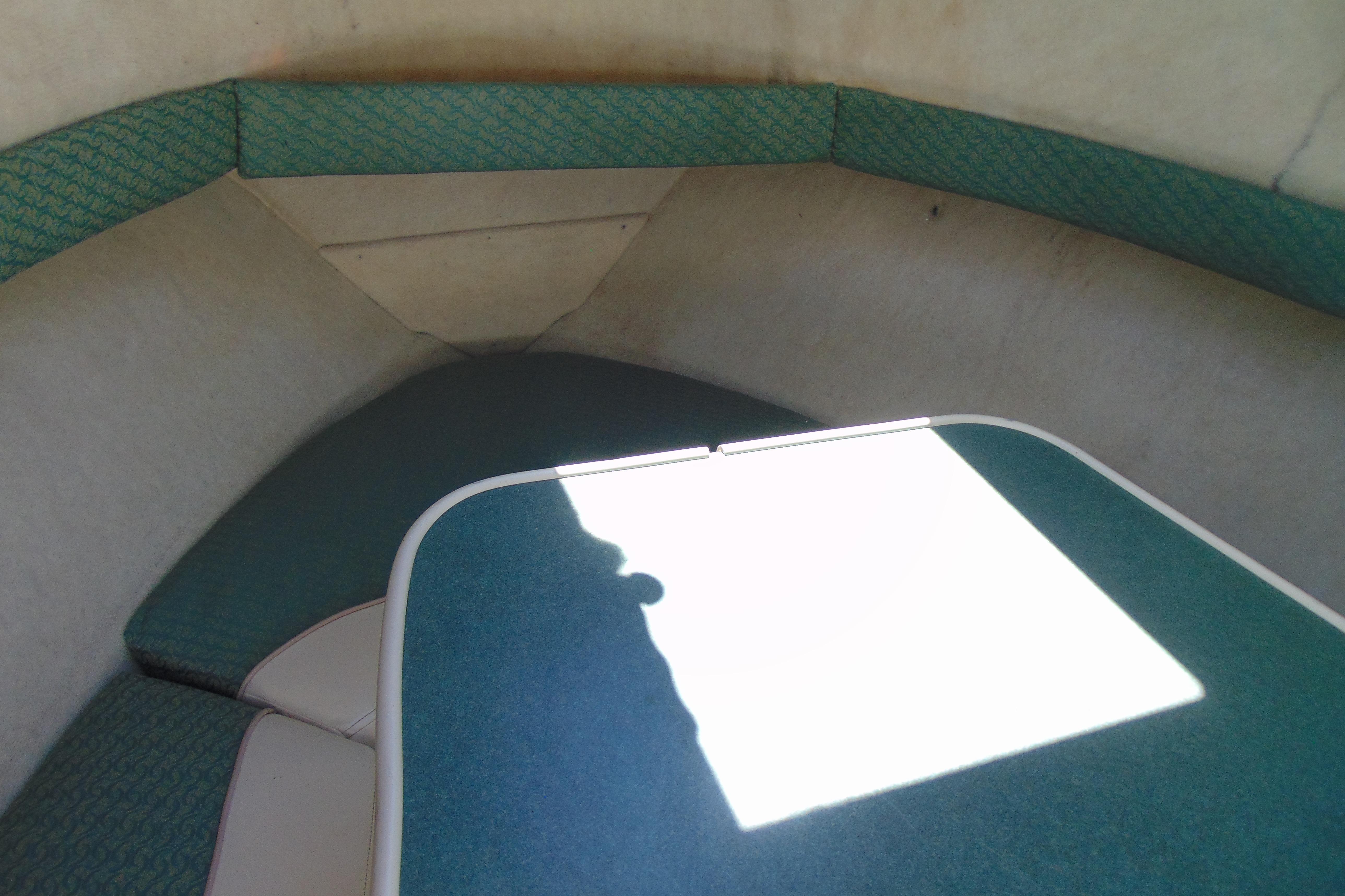 Interior cabin of a 2002 Trophy Walkaround boat, featuring teal upholstery and compact design.