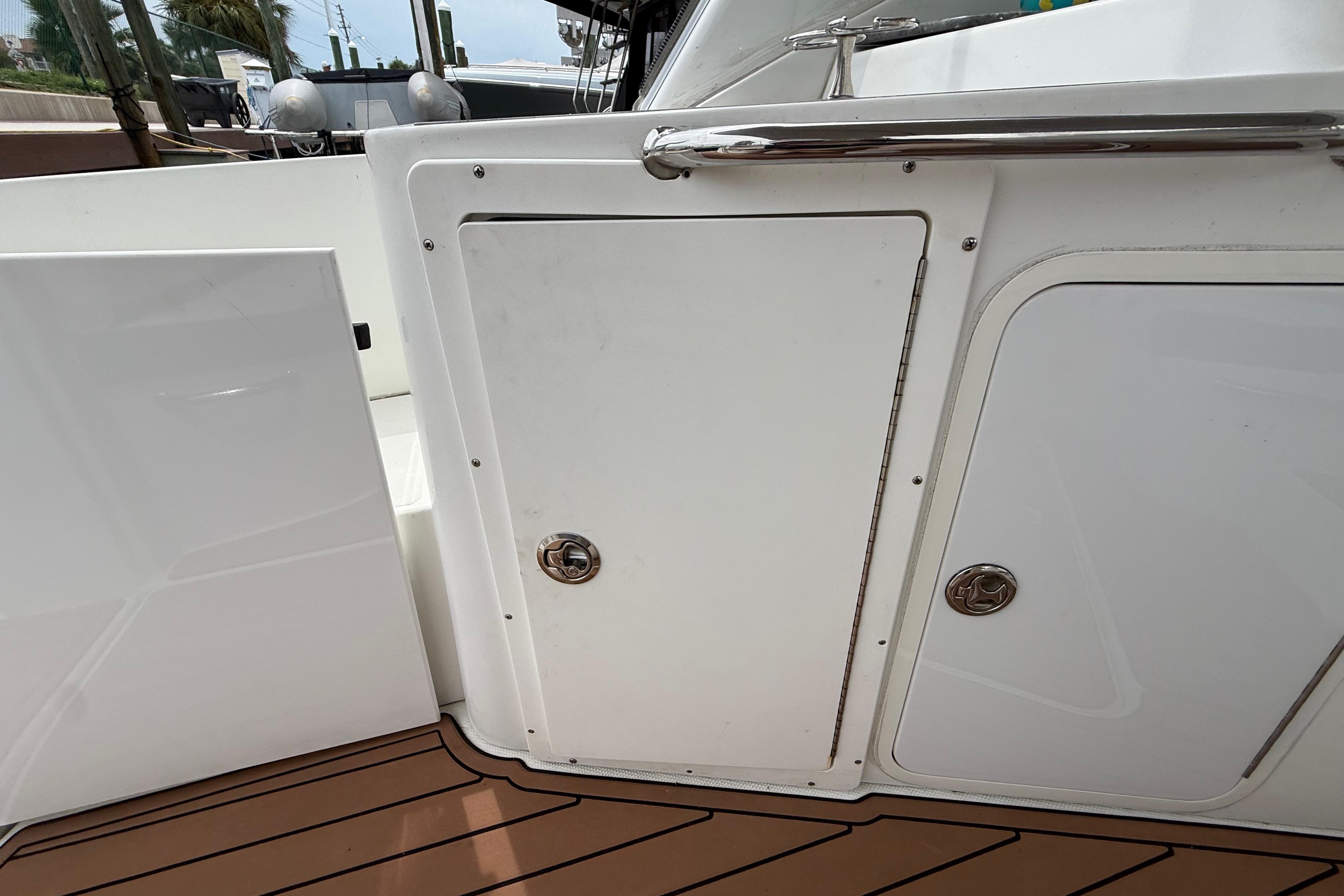 2008 Cruisers Yachts 330 Express boat deck with storage compartments and teak flooring.