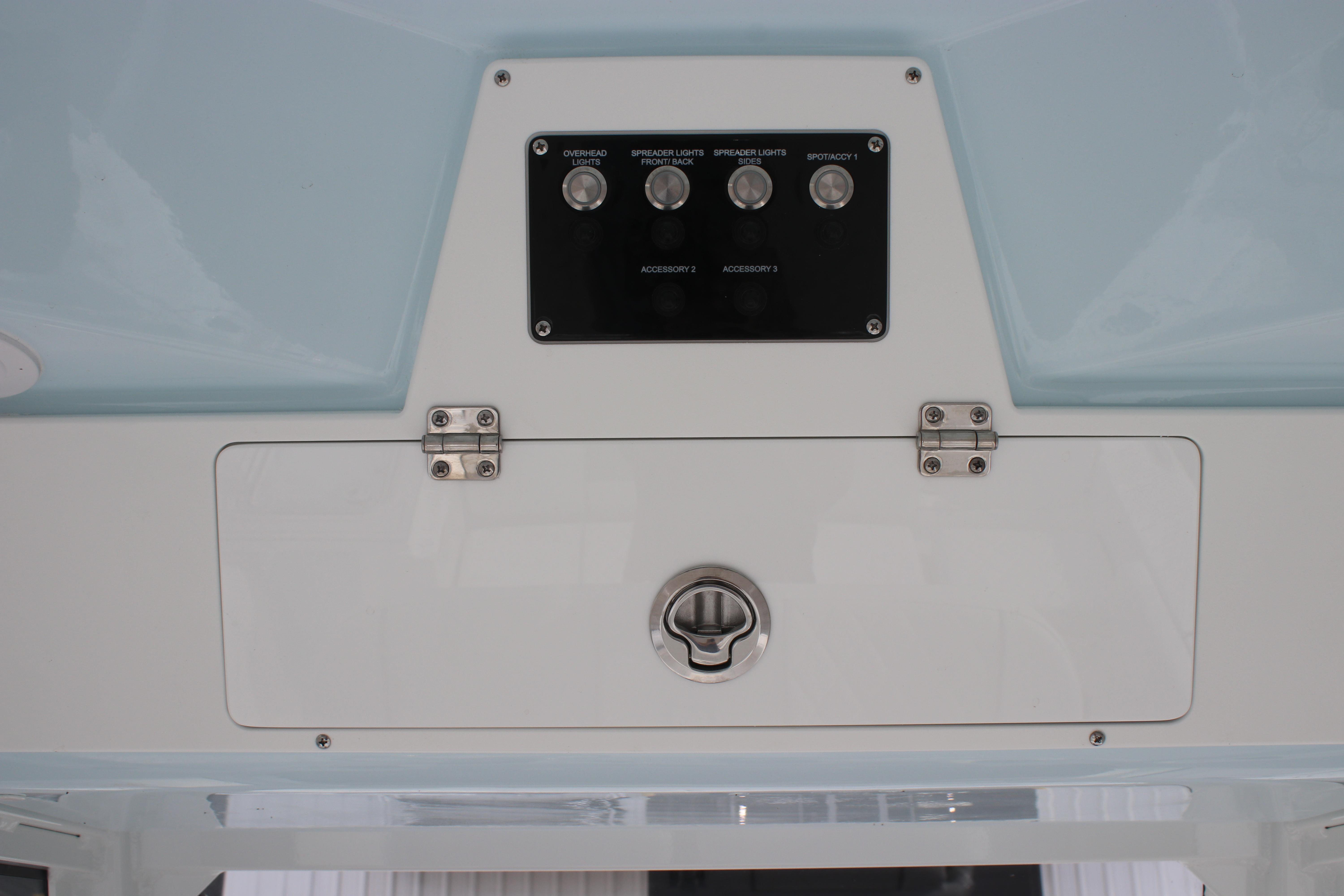 Control panel of 2026 Sea Fox 248 Commander boat with switches and storage compartment.