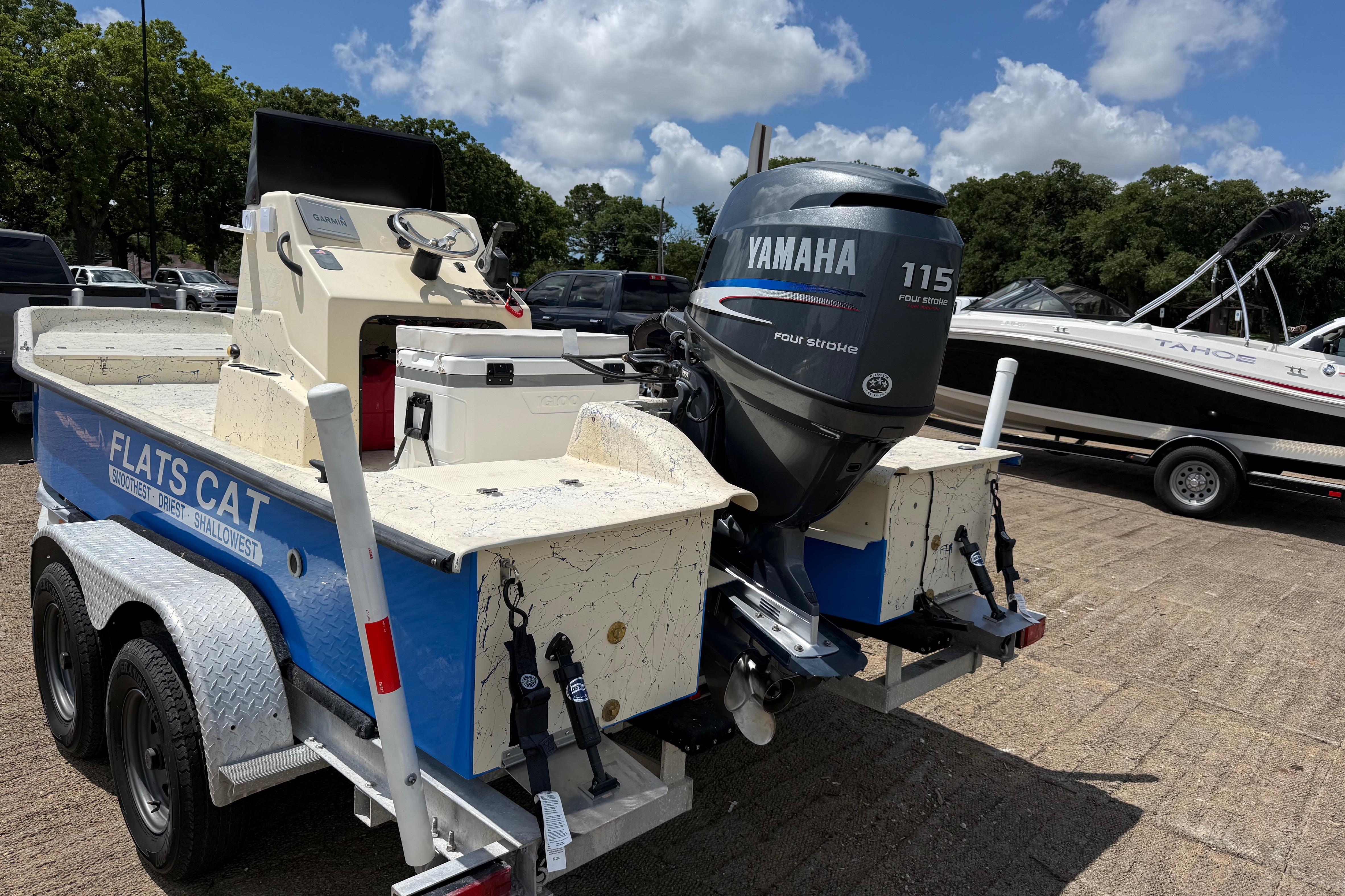 2007 Flats Cat 19 boat with Yamaha 115 engine on trailer, parked outdoors.