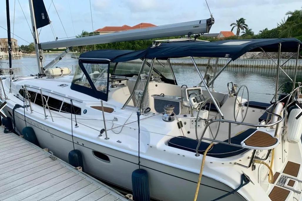 Hunter Aft Cockpit 50 sailboat, 2012 model, docked by a serene waterfront.