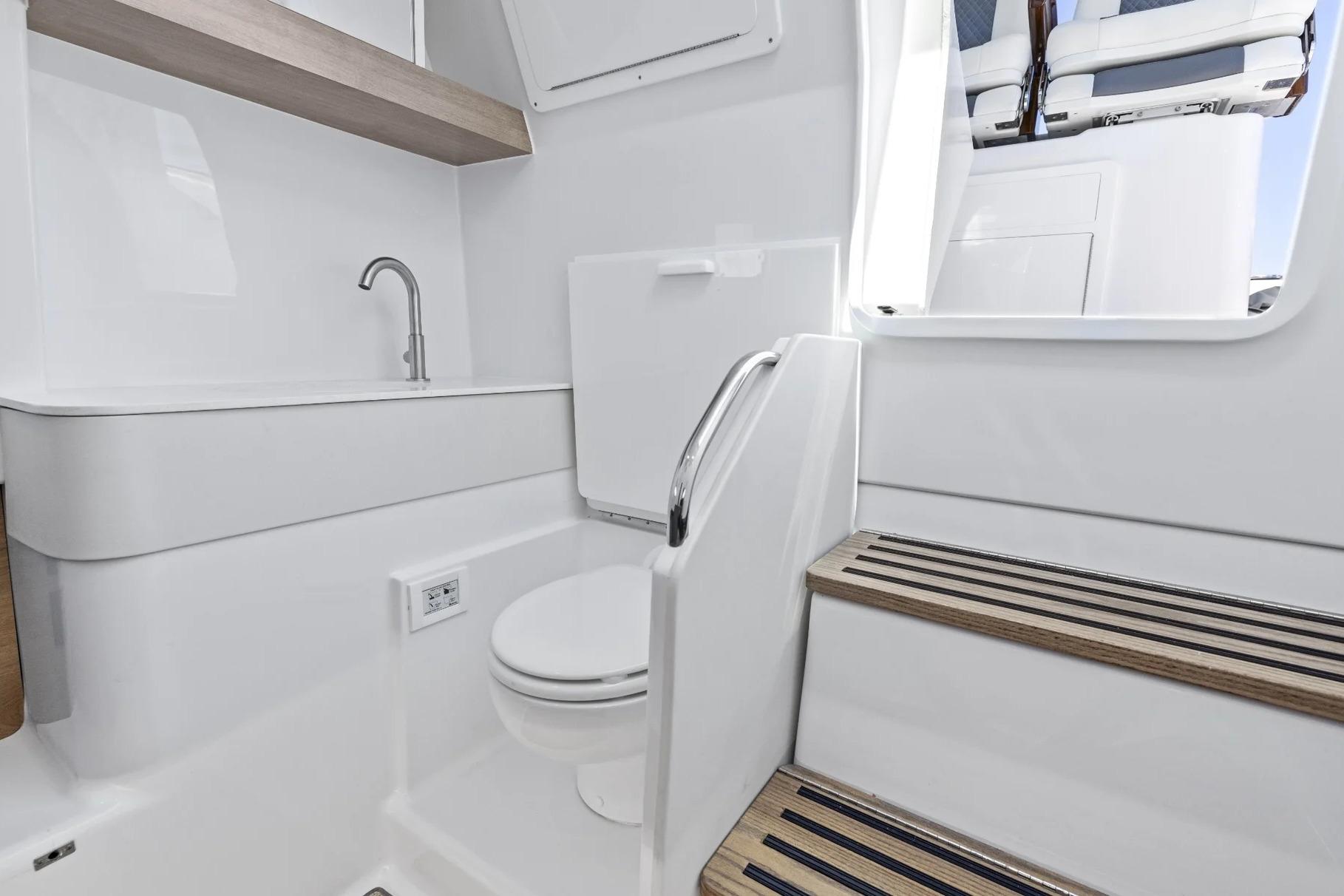 Manufacturer Provided Image: 2026 Bertram 34 CC boat interior with modern bathroom and wooden steps.