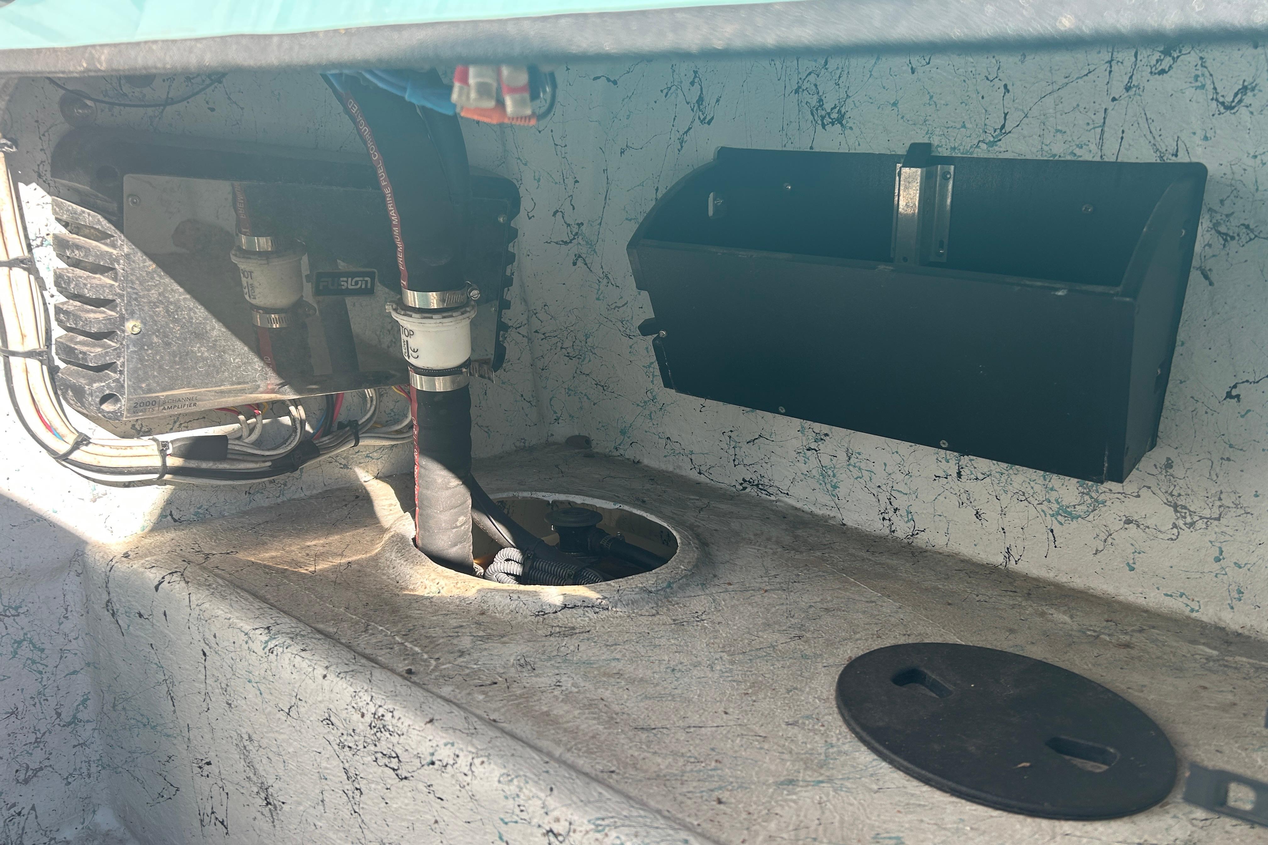 Interior view of a 2021 Shallow Stalker Cat 240 Pro Elite boat, showing wiring and storage compartment.