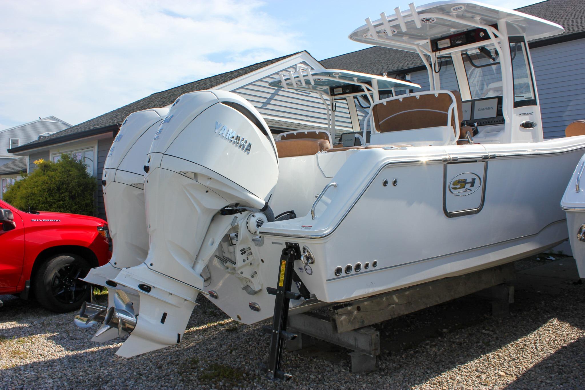 2027 Sea Hunt Ultra 275 SE boat with dual Yamaha outboard engines, parked on gravel.