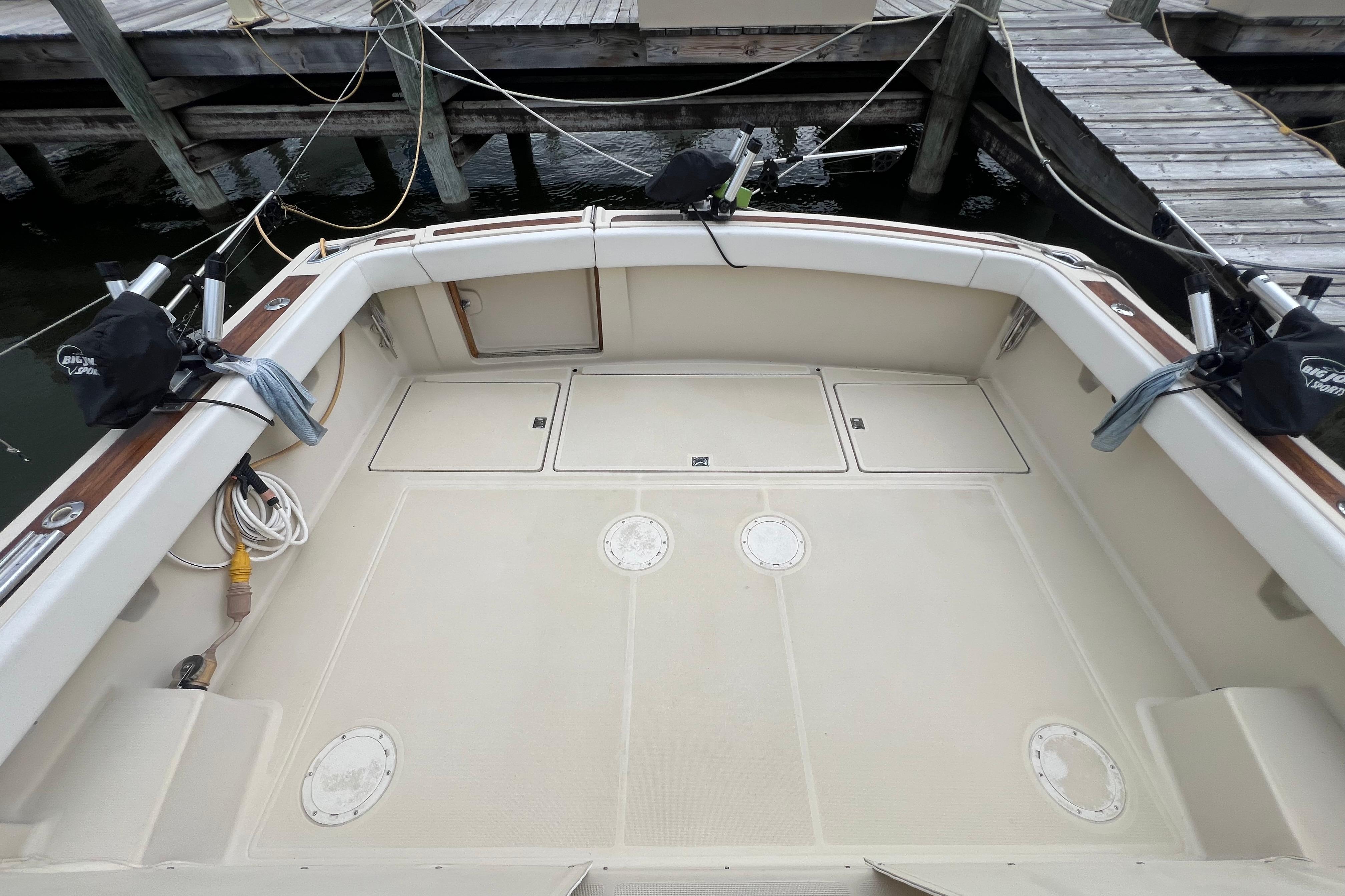 1985 Tiara 36 OPEN boat deck with storage compartments and fishing rod holders.