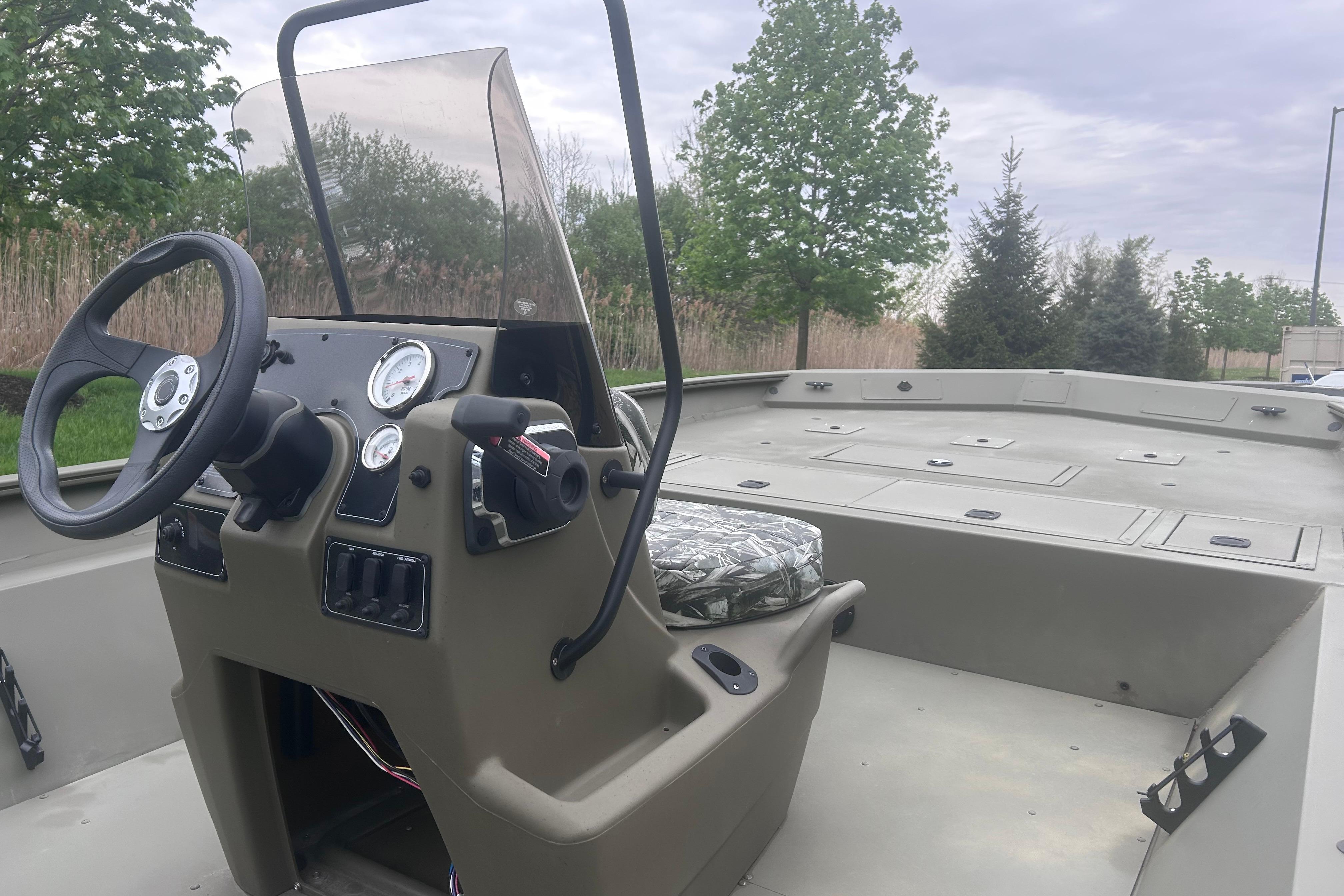 2024 Tracker Grizzly 2072 CC boat interior with steering console and seating.