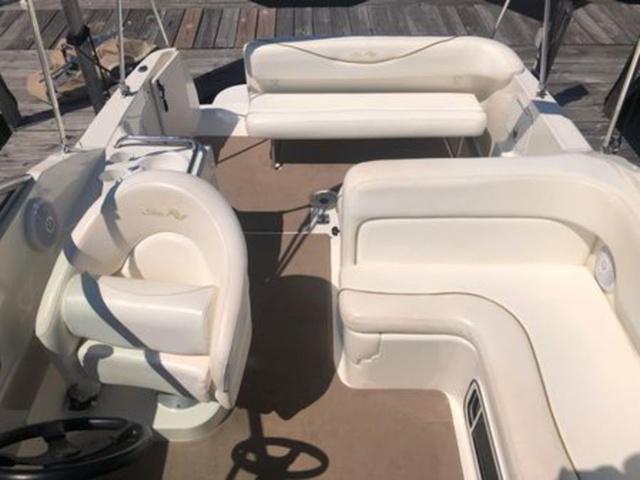 2003 Sea Ray 260 Sundancer boat interior with white seating and steering wheel.