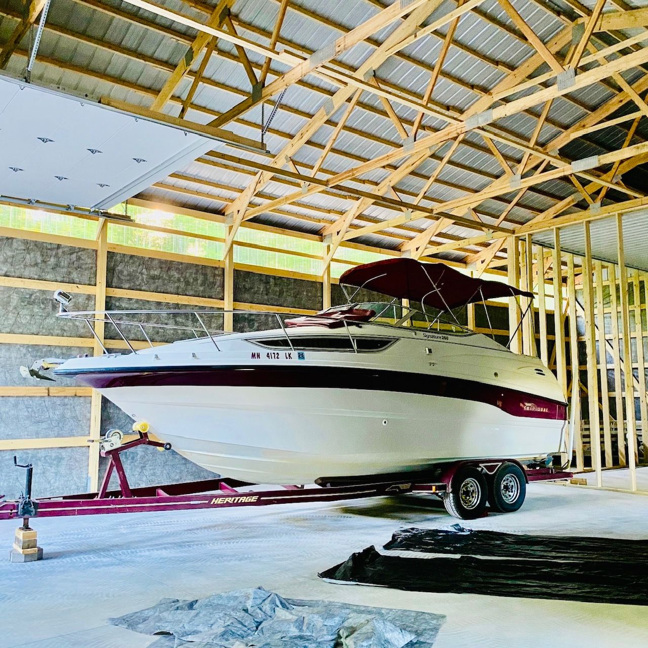 A 1997 Chaparral Signature 260 boat on a trailer inside a barn.