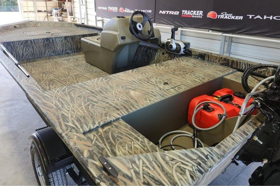 2026 Tracker Grizzly 1648 SC boat with camo design in a showroom.