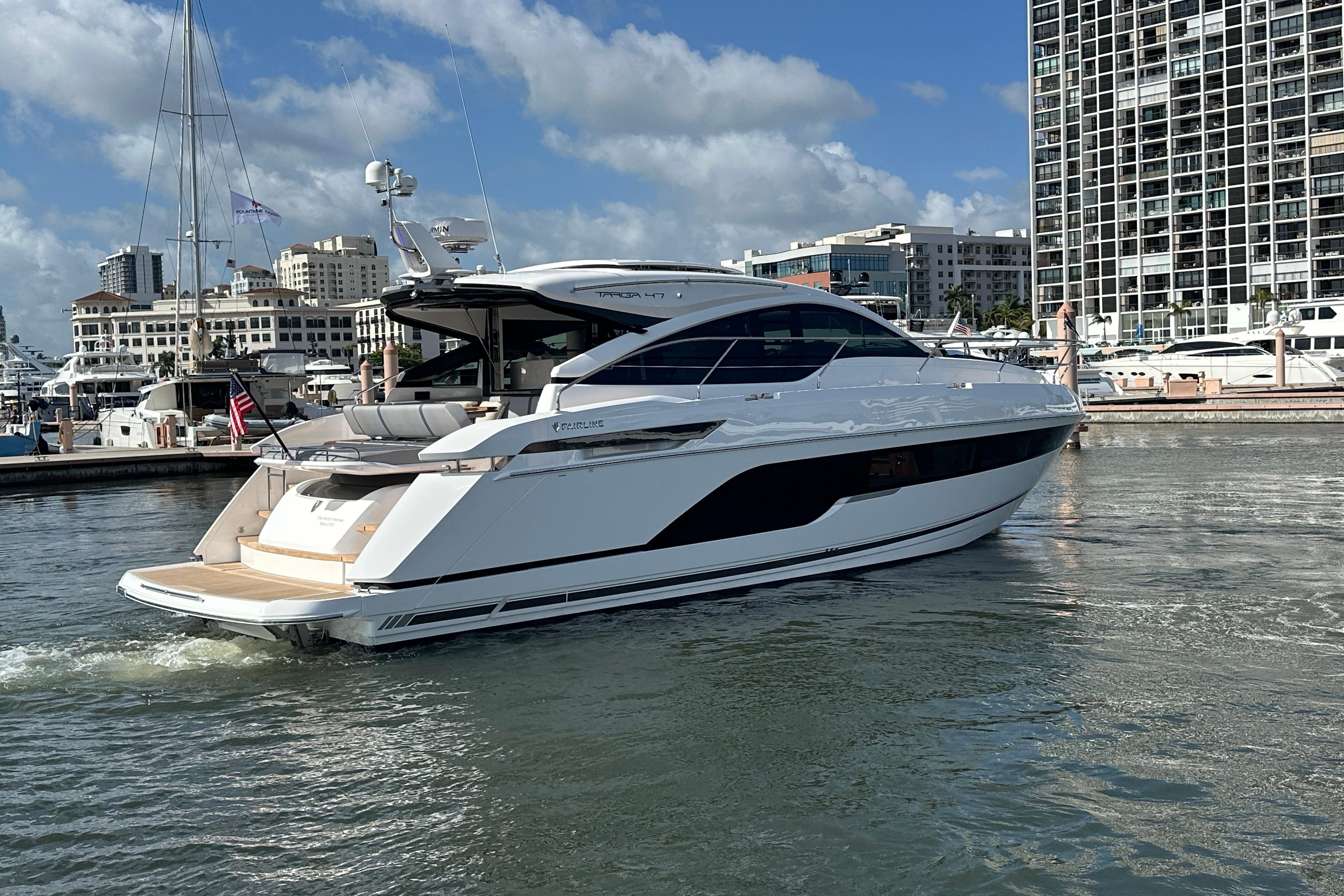2026 Fairline Targa 47 GT yacht docked in a marina, with cityscape background.