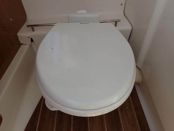 Boat toilet in 2011 Chaparral 287 SSX, featuring wooden flooring.