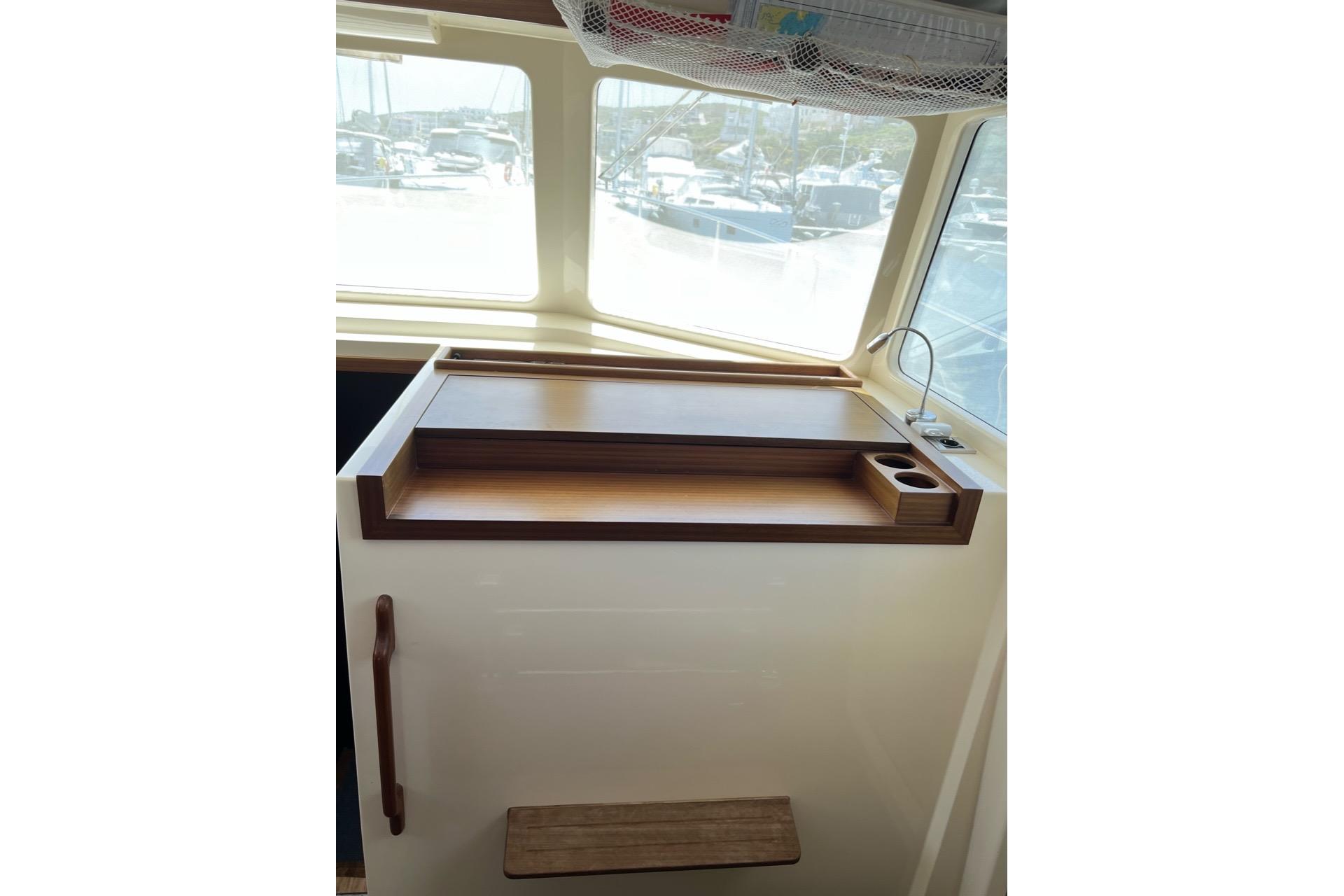 Interior of 2019 Rhea Trawler 36 with wooden desk and window view.
