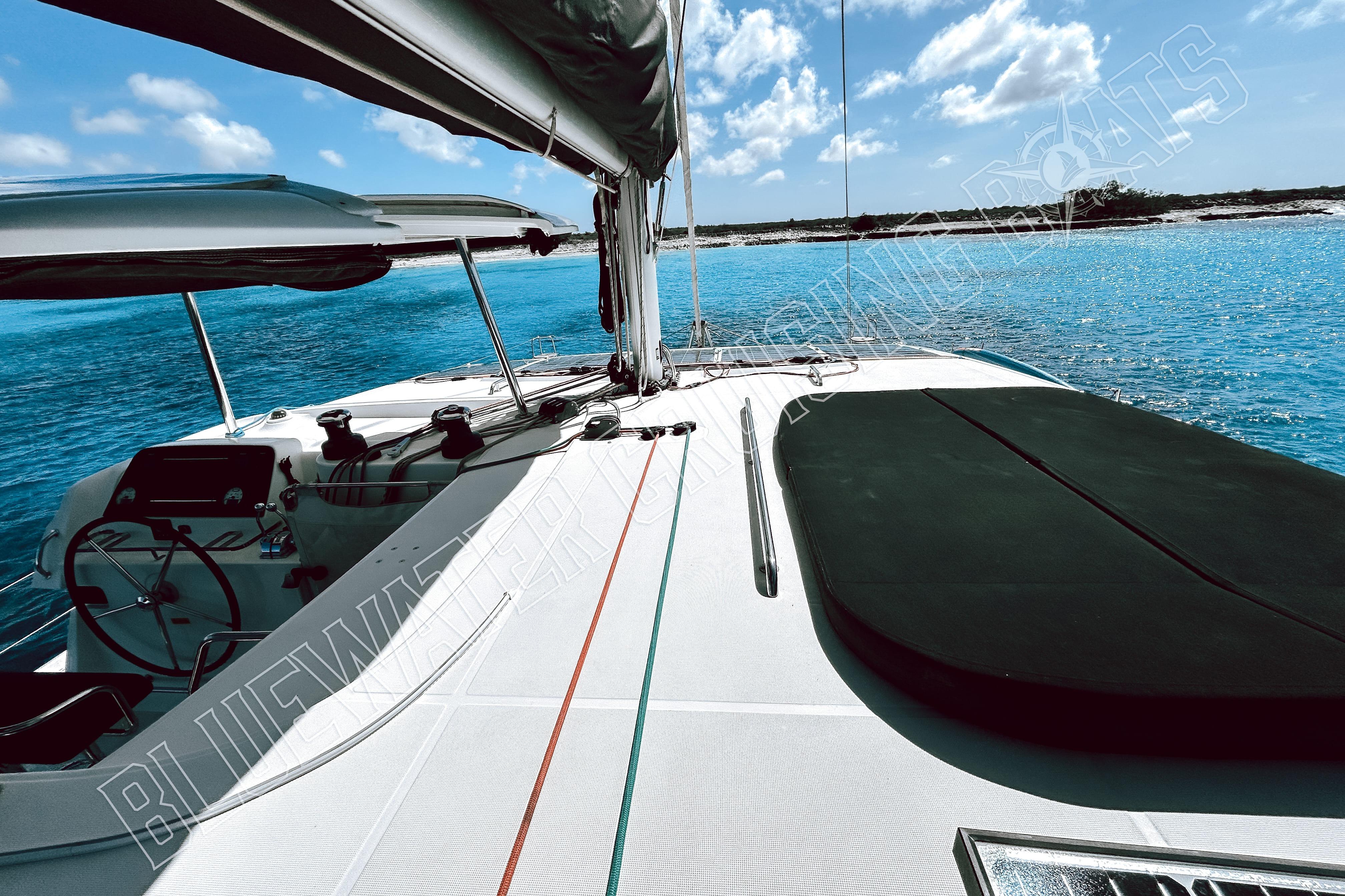 2018 Lagoon 42 catamaran sailing on clear blue waters under a sunny sky.