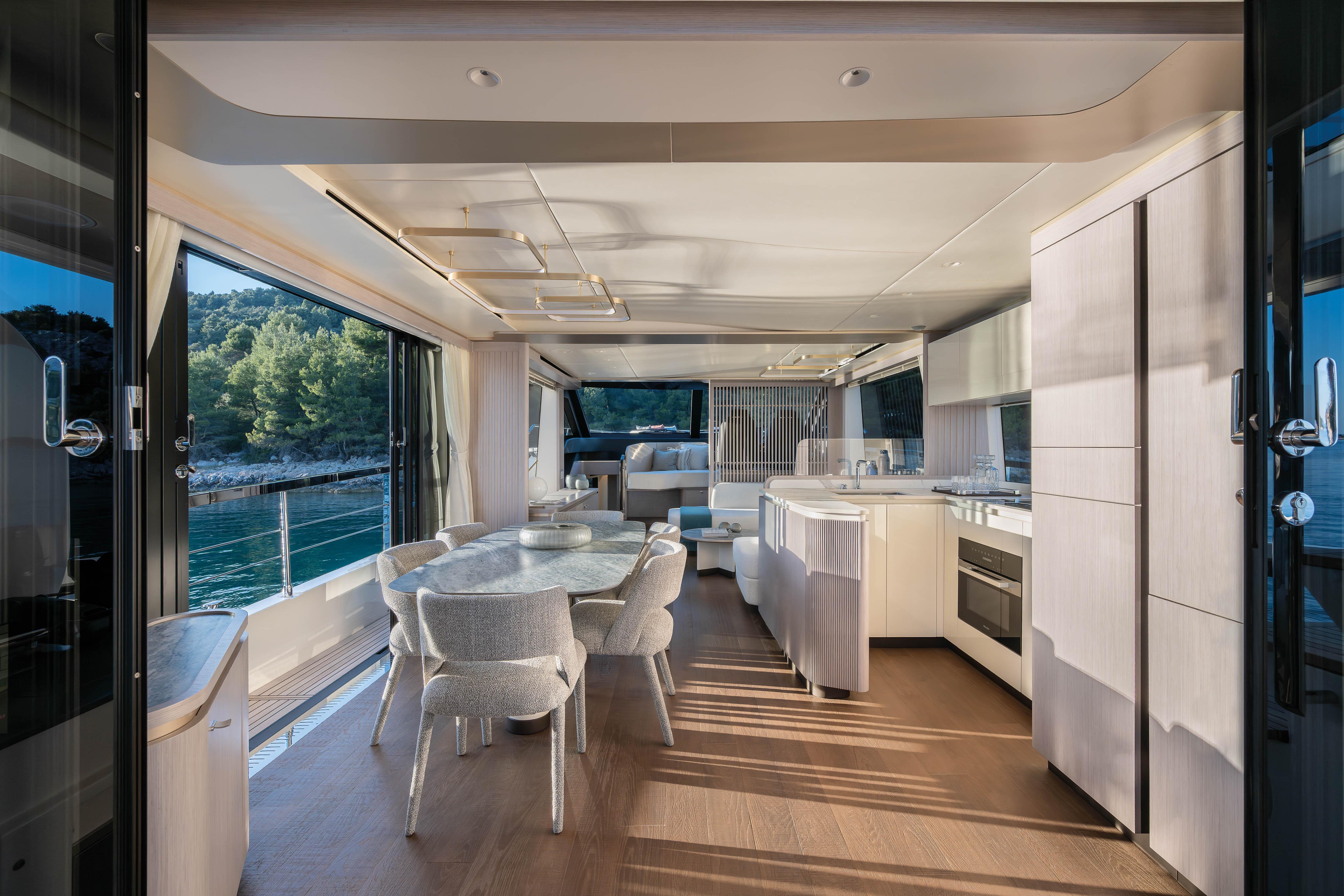 Interior view of a luxury yacht with modern dining area and kitchen.