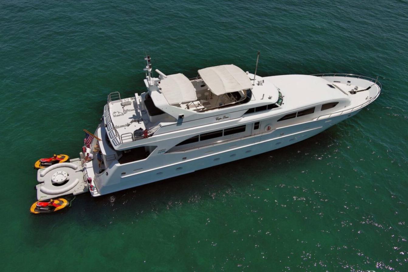 Luxury 2001 Intermarine RPH 95 yacht on clear blue water with jet skis attached.