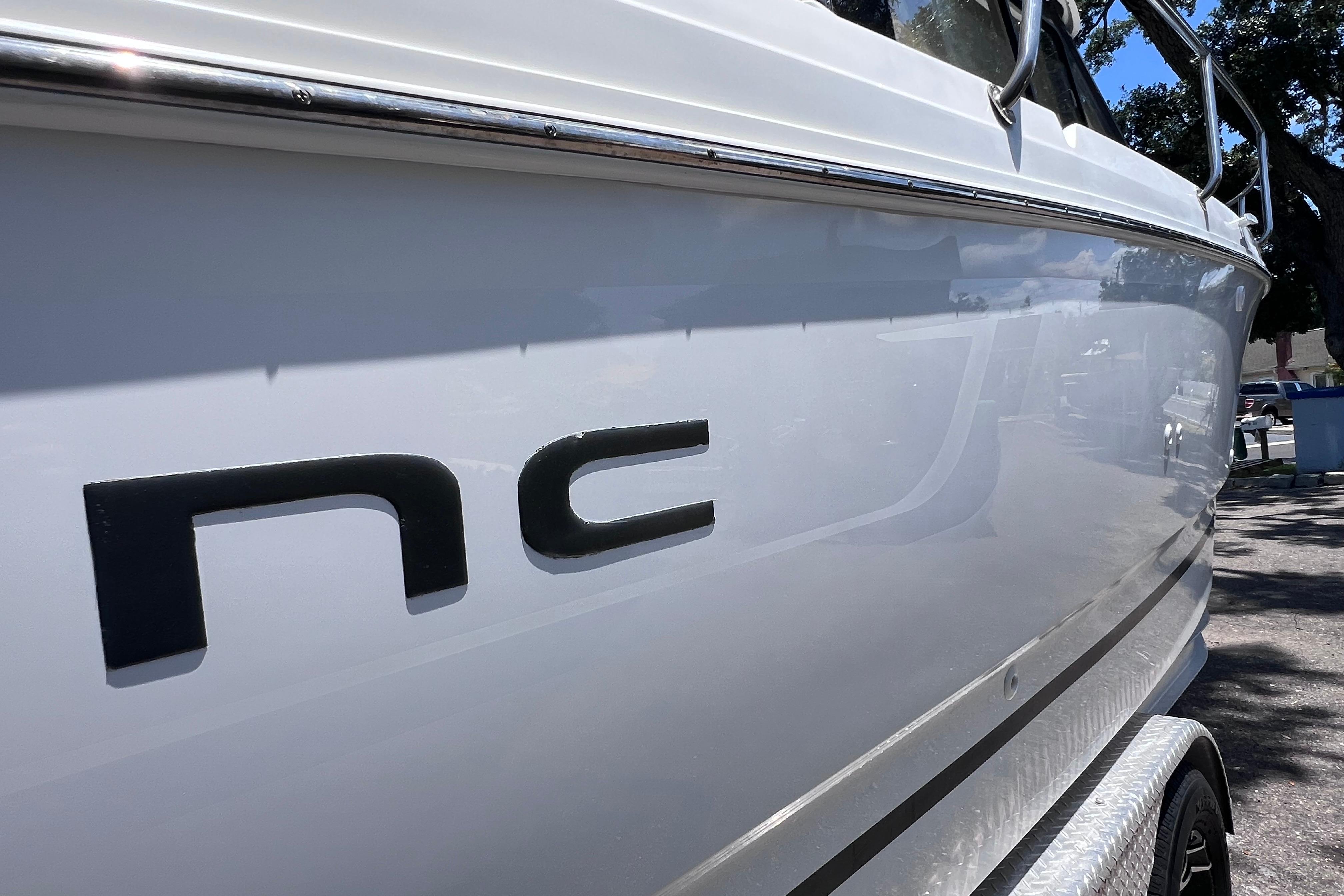 Side view of a 2021 Jeanneau NC Weekender 795 Series 2 boat in sunlight.