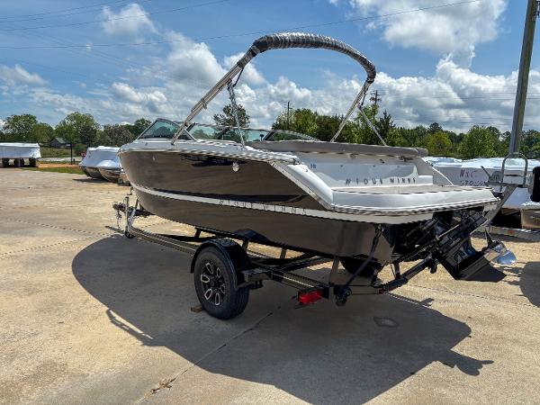2023 Four Winns H1 boat on trailer, parked outdoors under a partly cloudy sky.