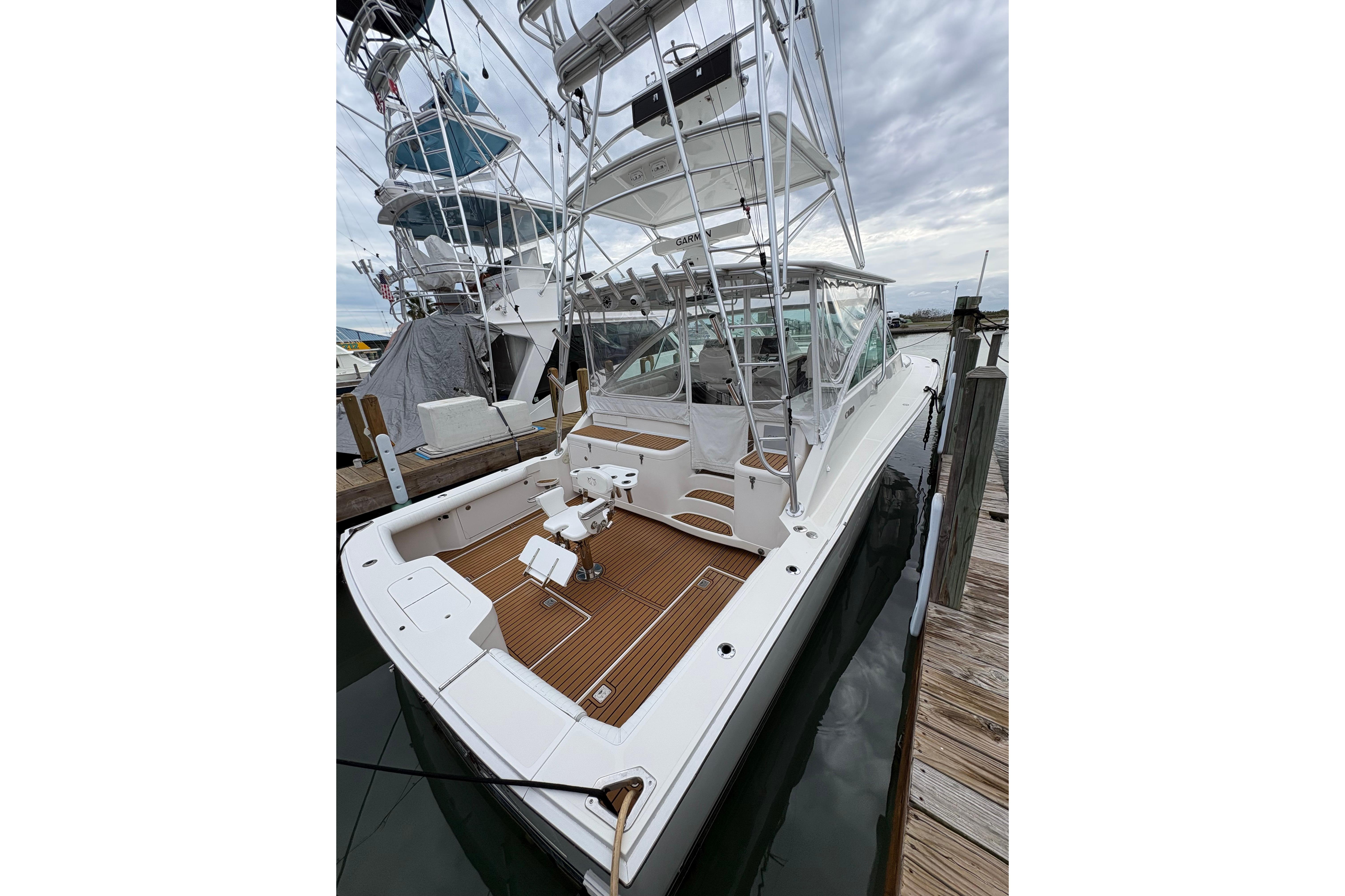 2004 Cabo 40 Hardtop Express yacht docked, featuring spacious deck and fishing chair.