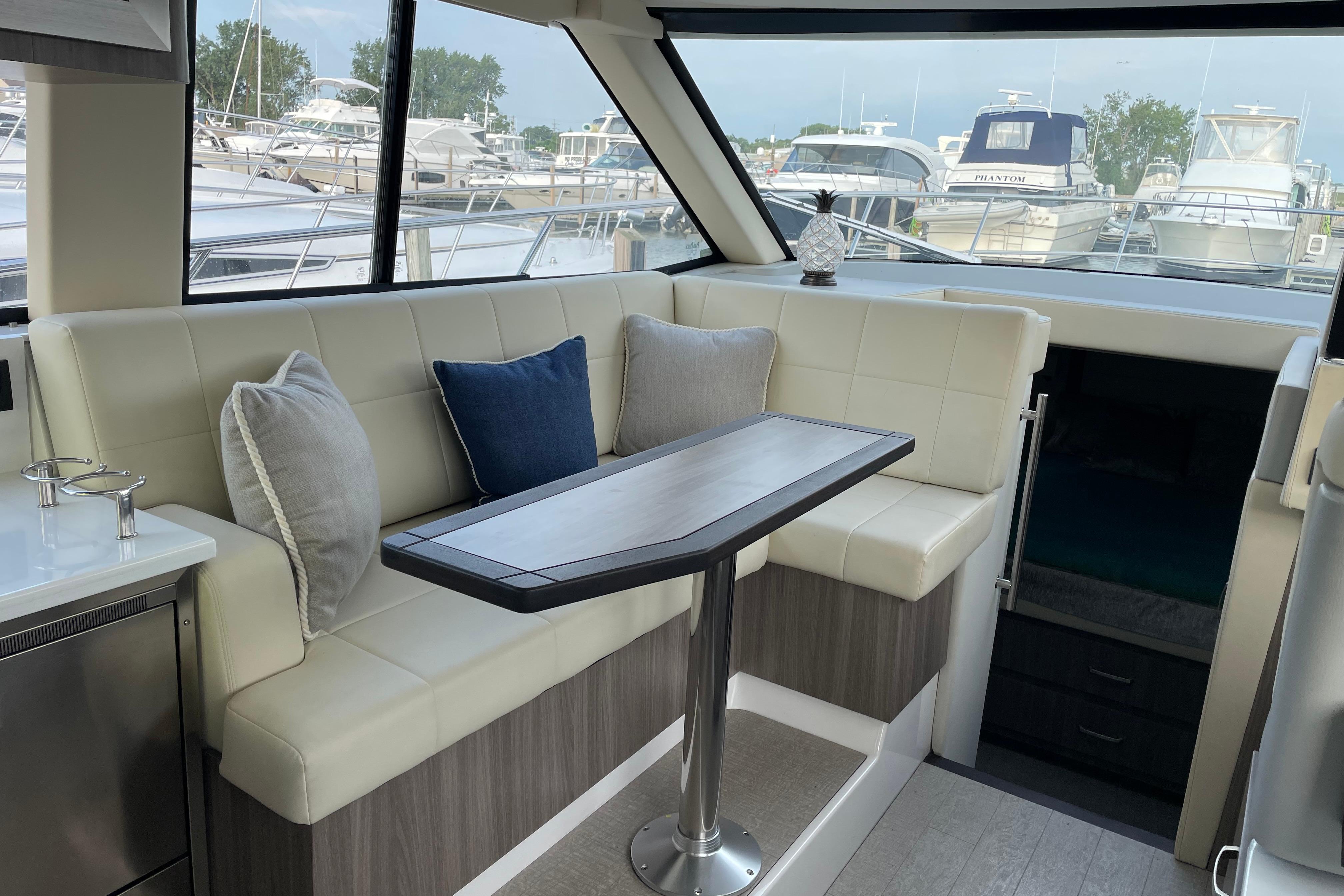 Interior of 2022 Regal 38 Grande Coupe yacht with elegant seating and table.