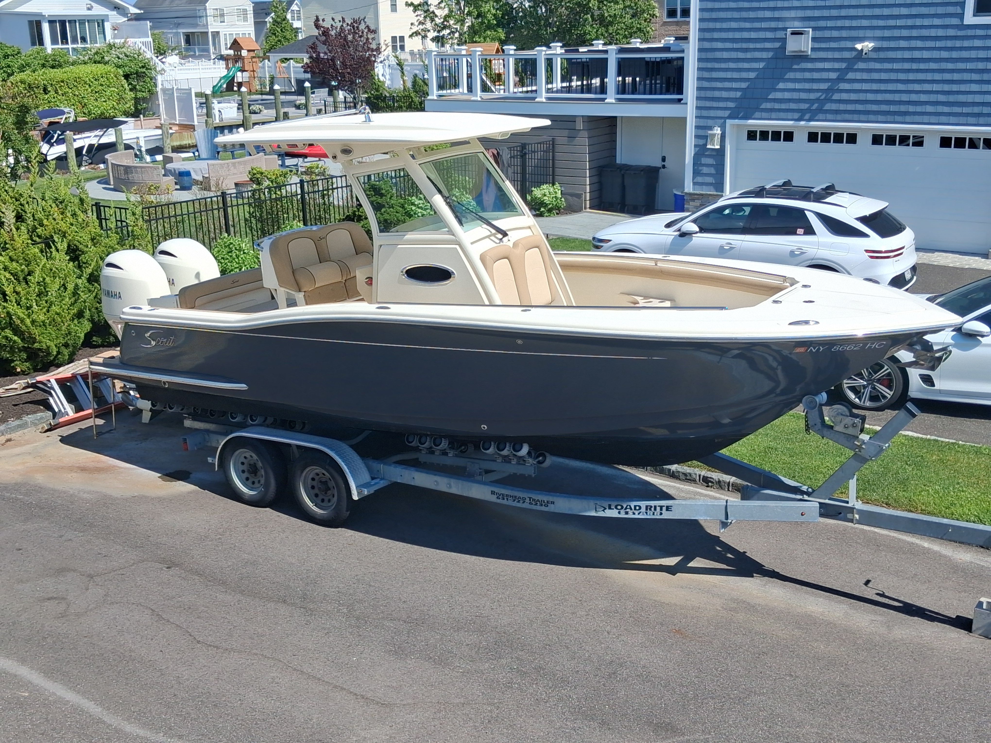2018 Scout 255LXF boat on trailer in residential area.