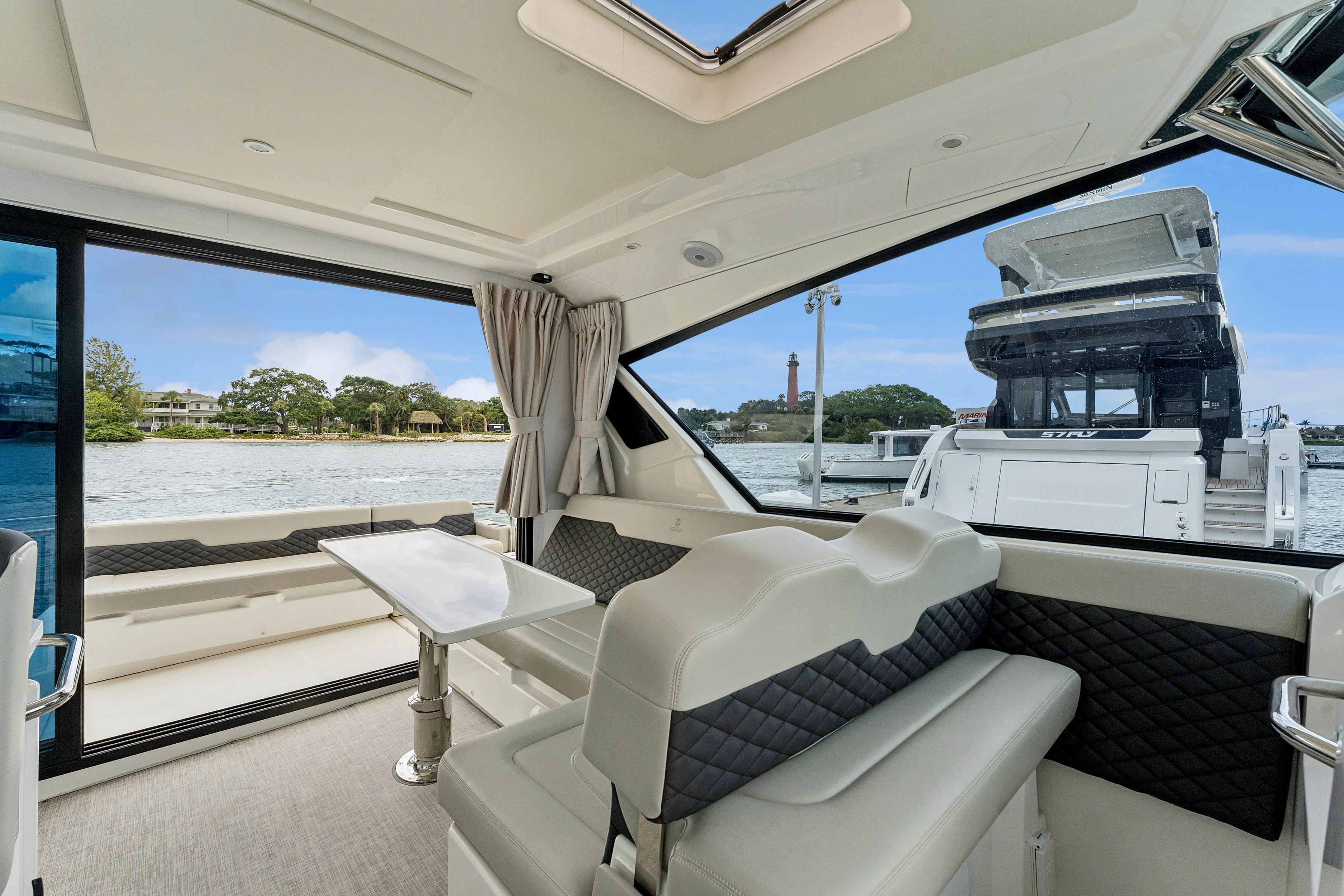 Interior of 2025 Aquila 36 Cruiser yacht with elegant seating and scenic water view.
