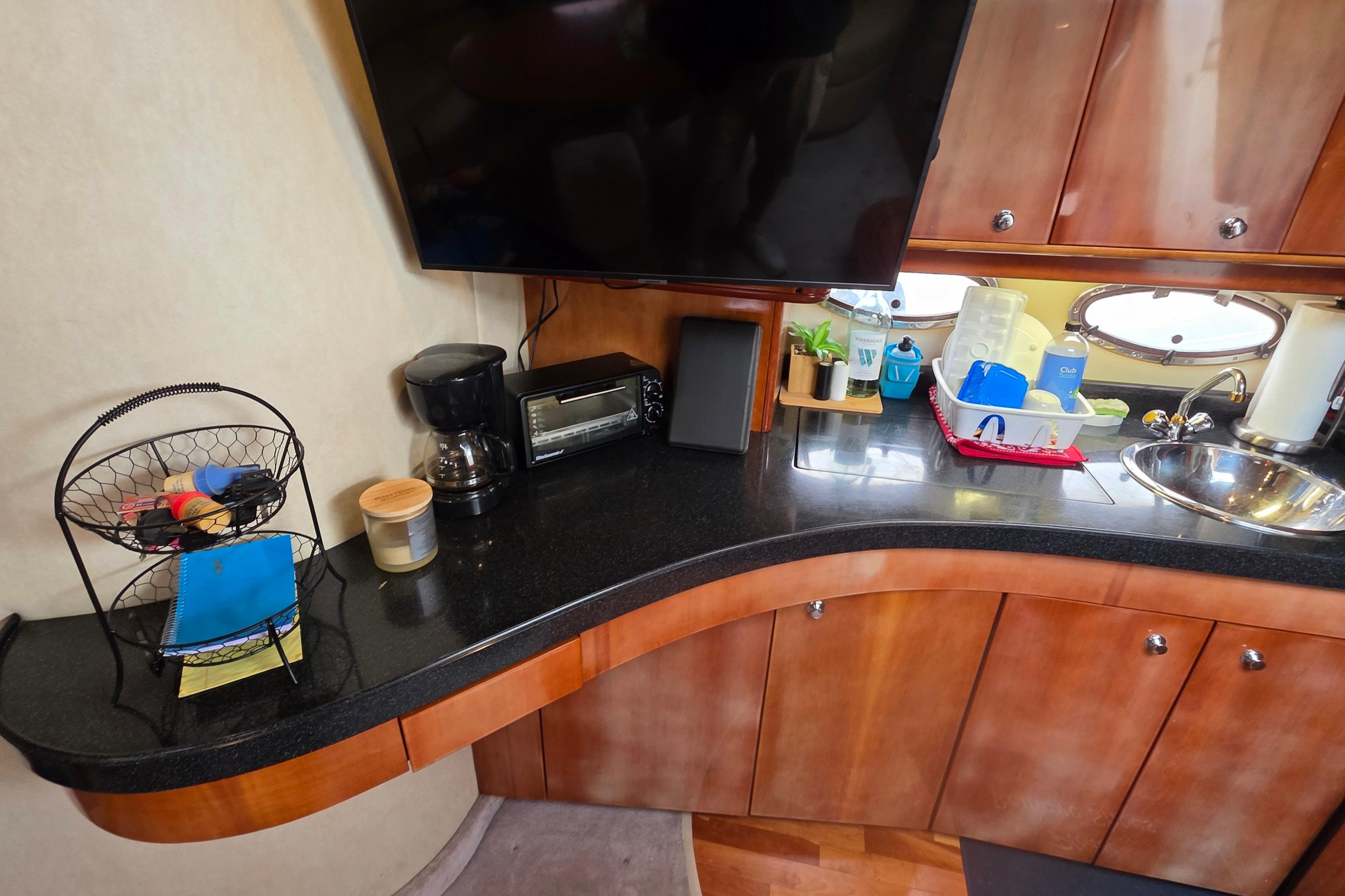 2002 Regal Commodore 4260 yacht kitchen with countertop, sink, and appliances.