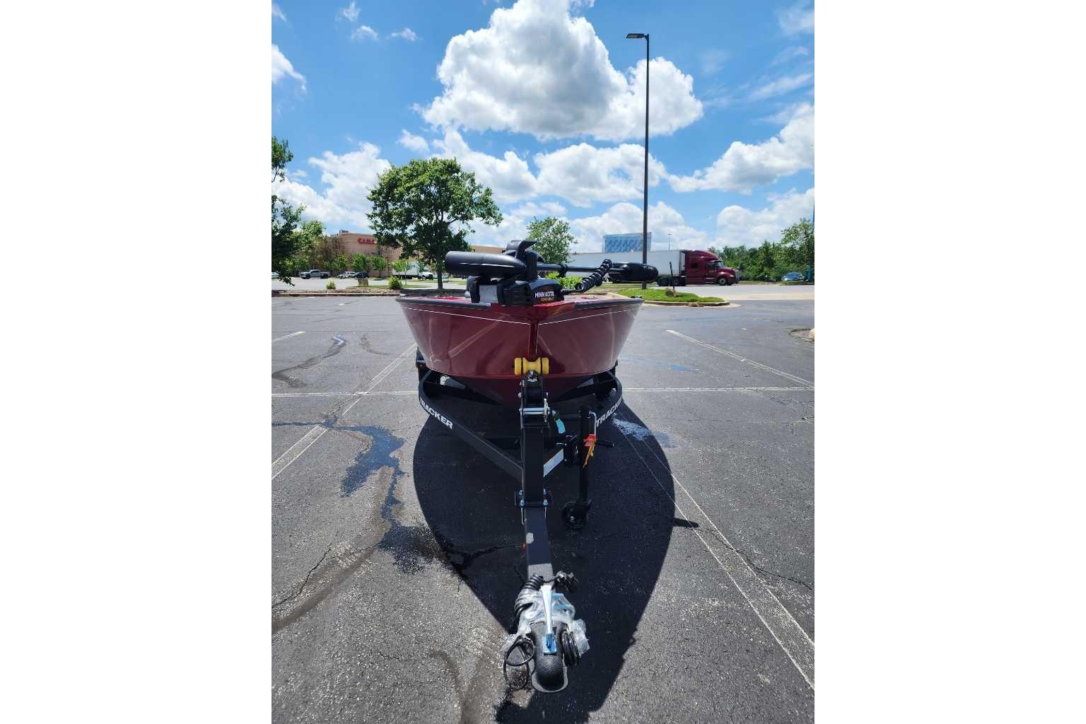 2025 Tracker Super Guide V-16 T boat on trailer in sunny parking lot.